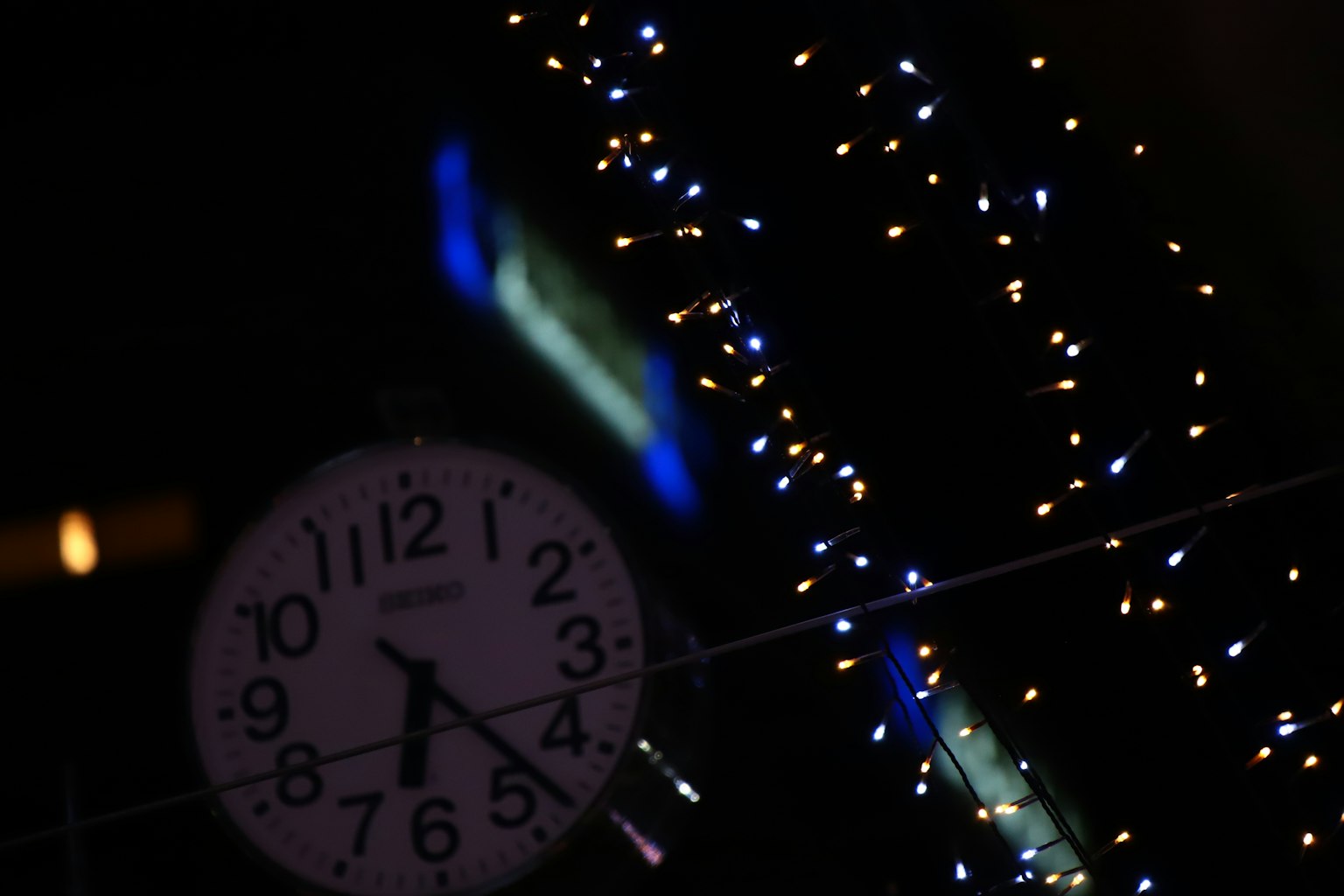 Uhr mit dekorativen Lichtern in einer nächtlichen Umgebung