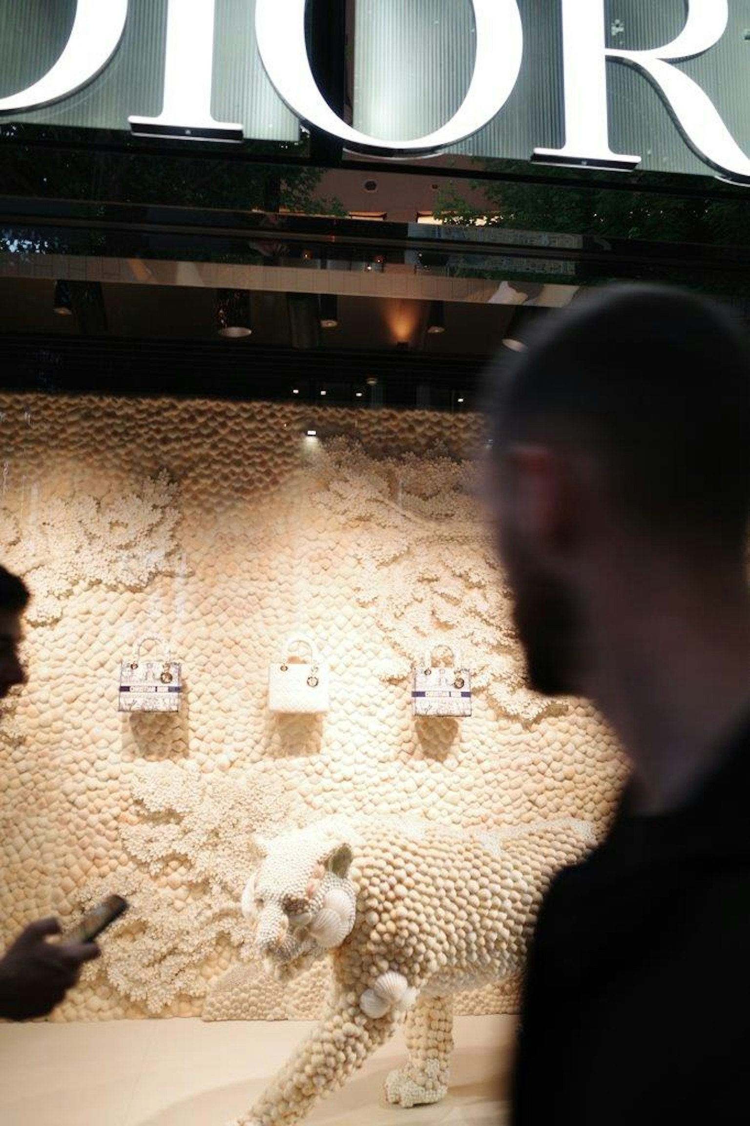 Leopardo bianco artistico nella vetrina Dior con sfondo testurizzato