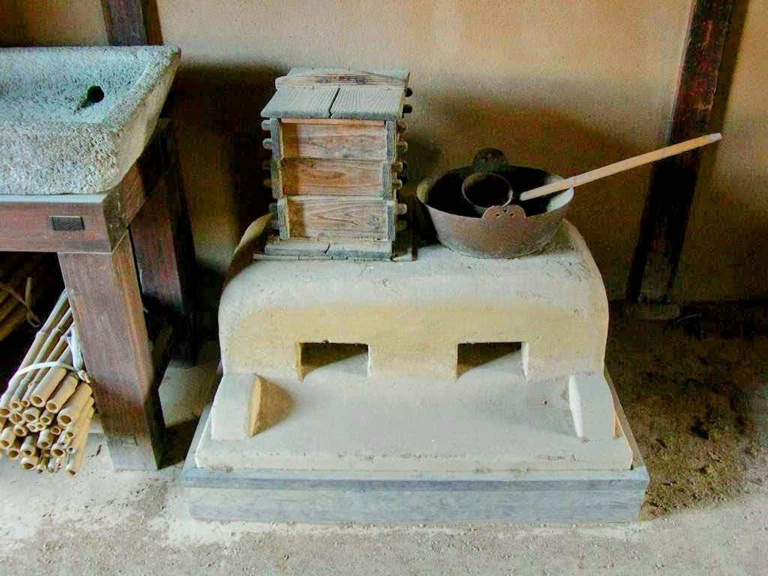 Sudut dapur tradisional Jepang dengan alat masak dari batu dan peralatan kayu