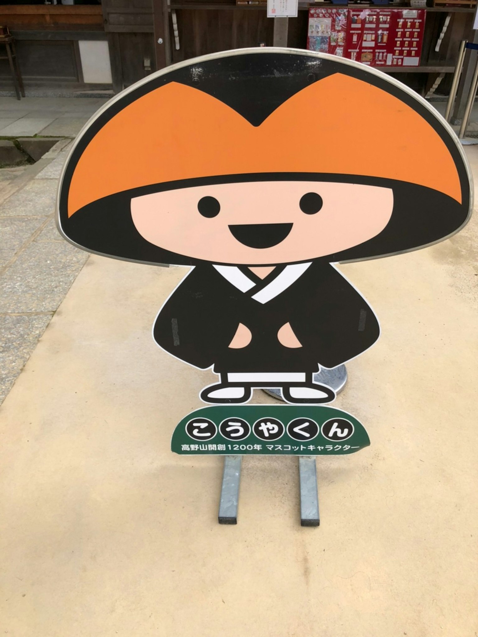 可爱的角色标志，戴着橙色帽子和黑色长袍