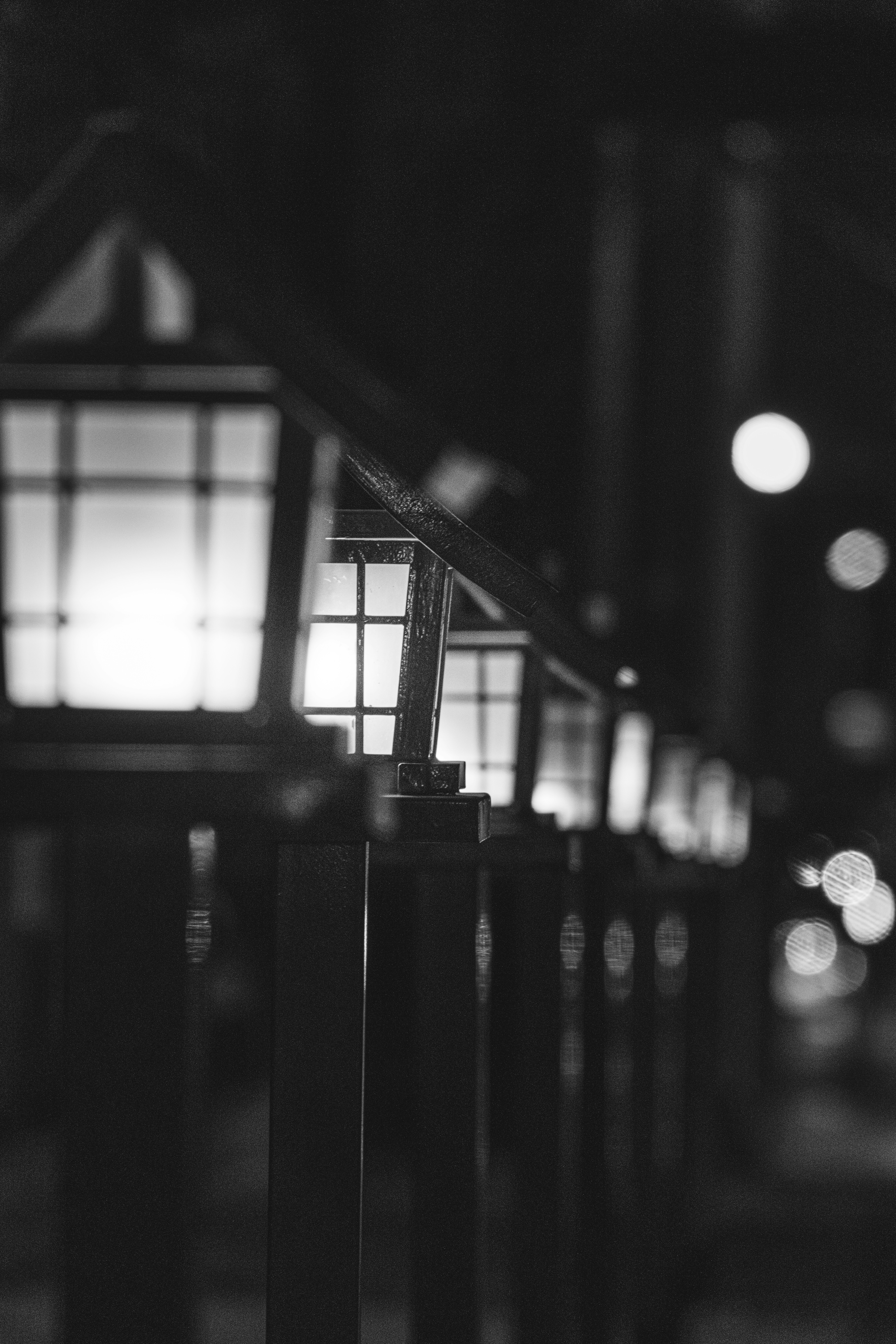 灯りがにじむ路地の格子と提灯のある夜景