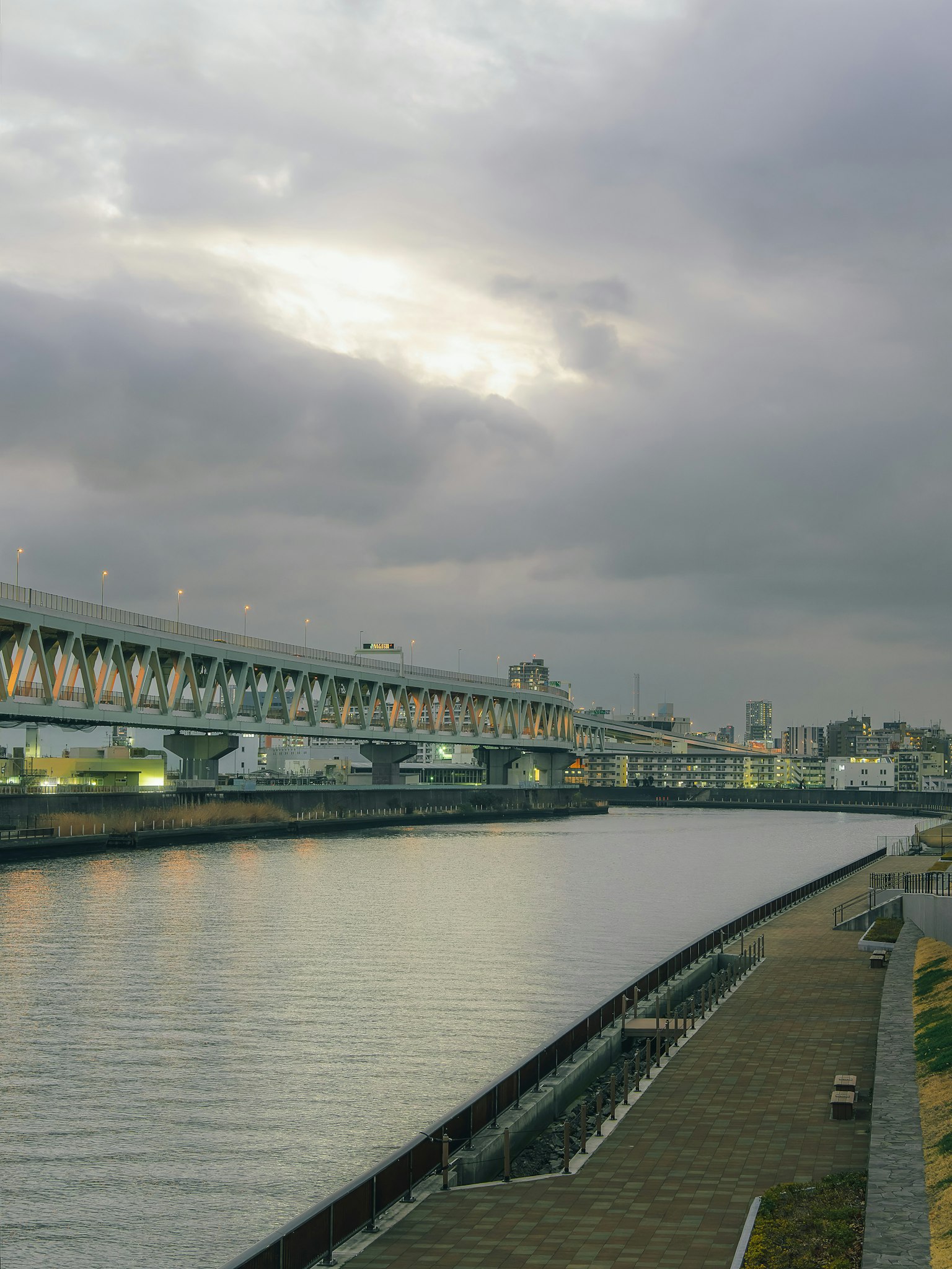 黄昏时的河流和桥梁场景，阴云密布