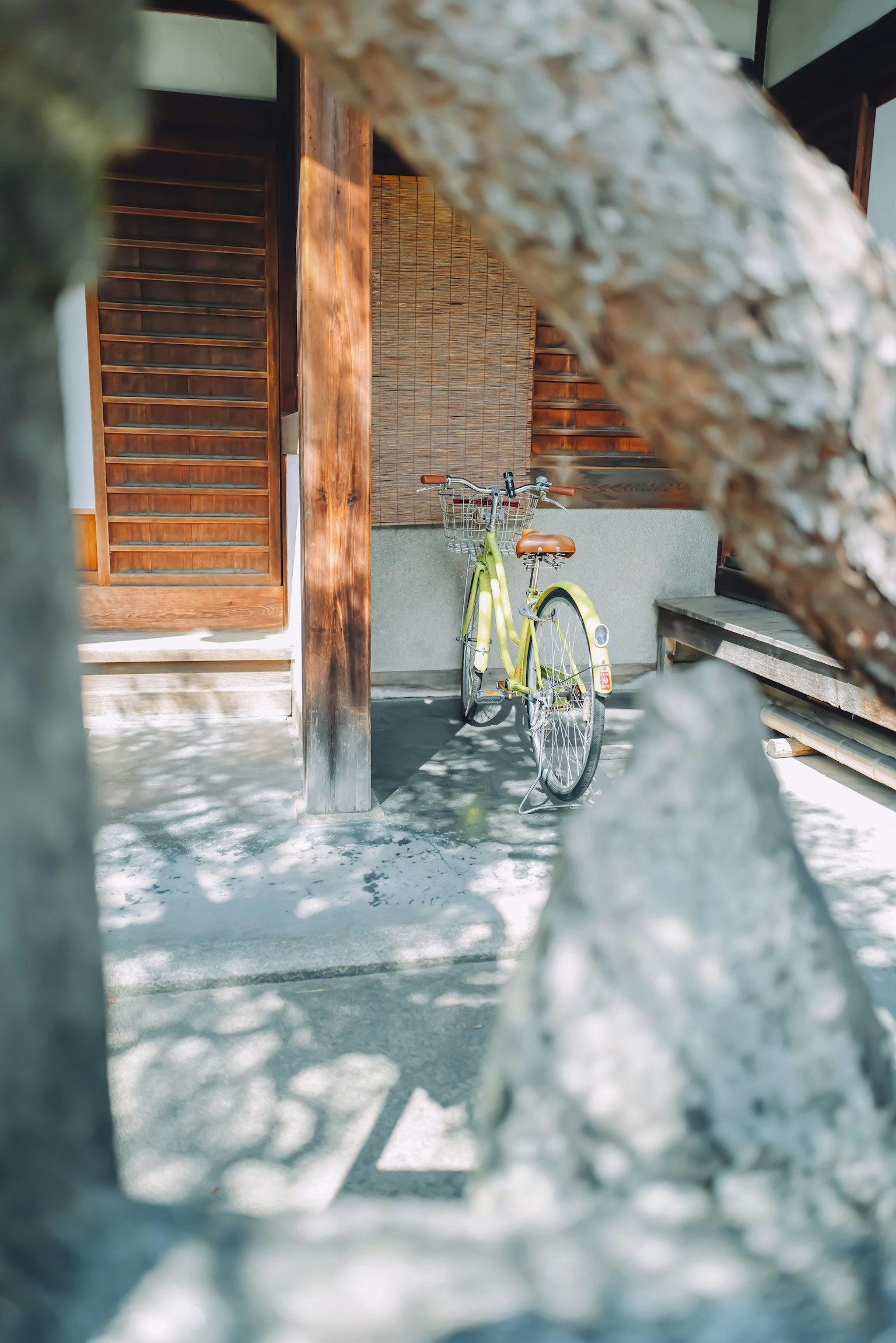 Una bicicletta verde parcheggiata nel cortile di una casa giapponese tradizionale con dettagli in legno