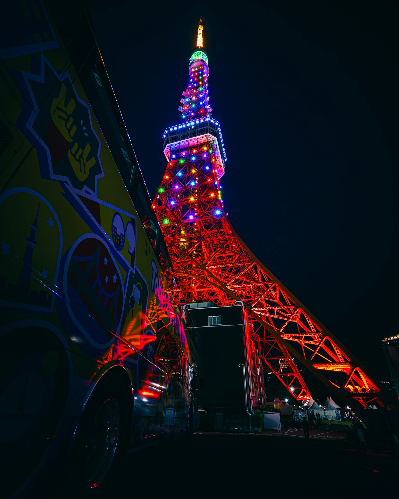 Menara Tokyo di malam hari diterangi lampu merah dan biru dari sudut rendah