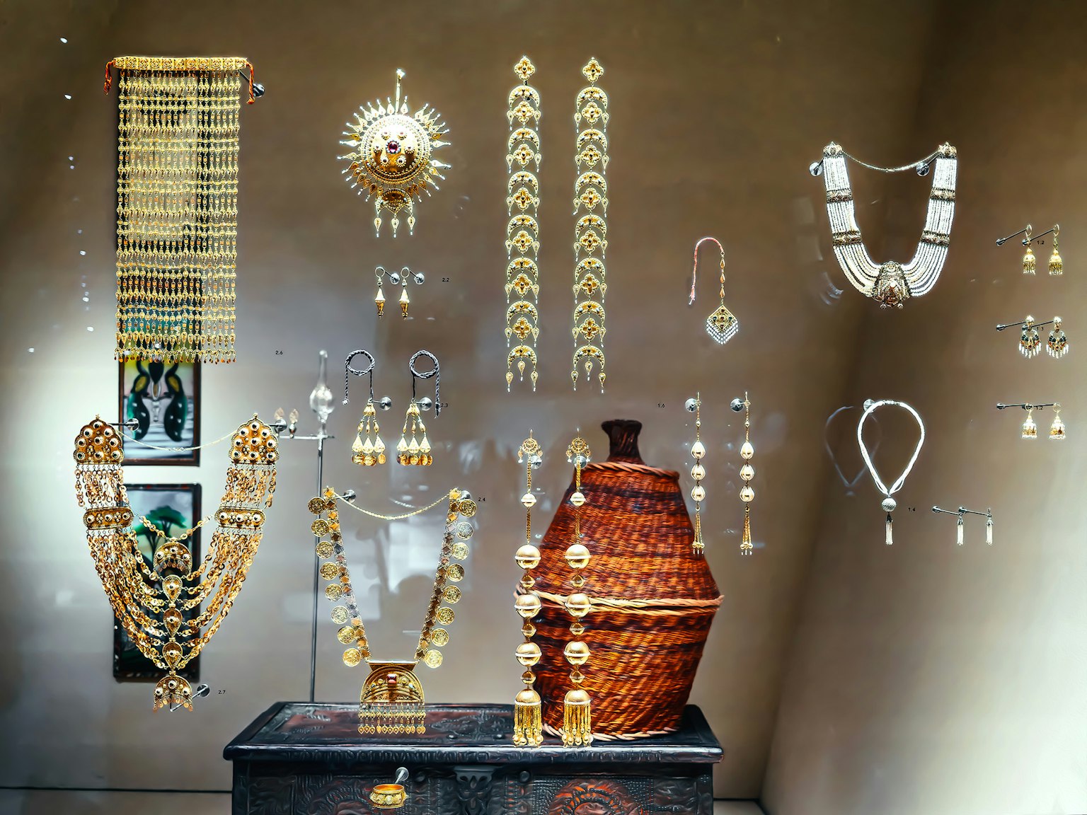 Display of gold jewelry in a museum case showcasing intricate designs