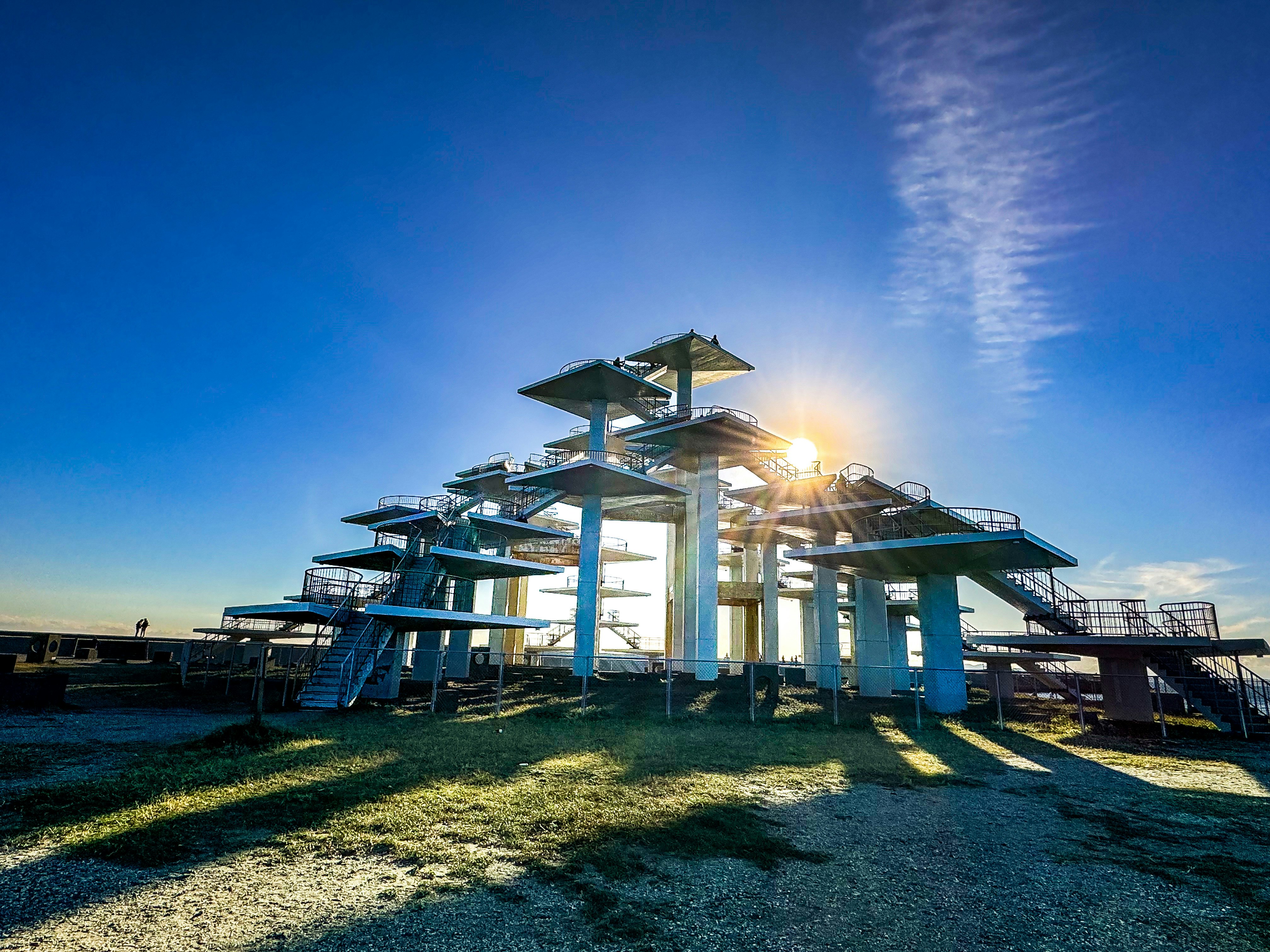 seaside observation deck with playground structures under a blue sky