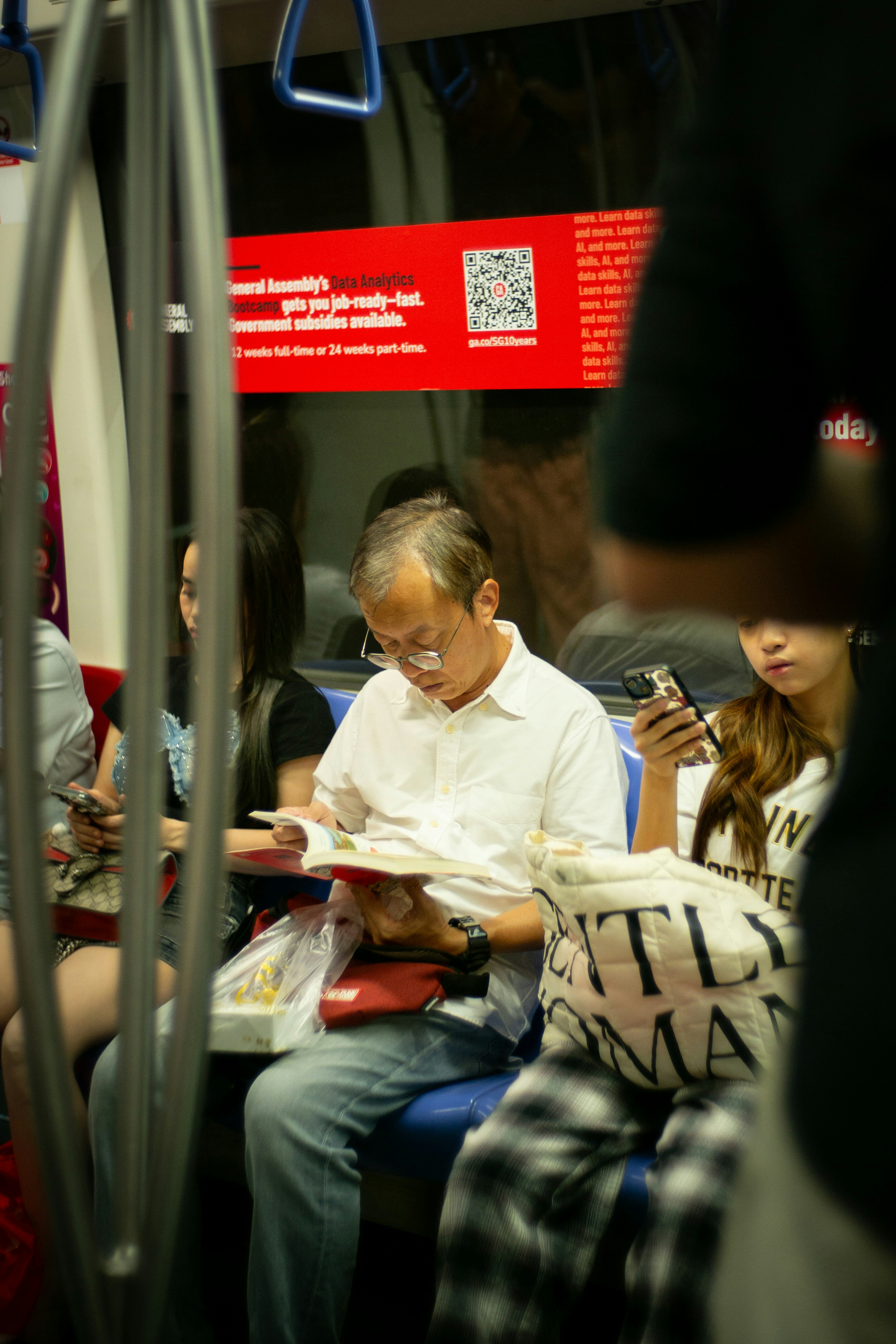 電車内で本を読む高齢女性と子ども