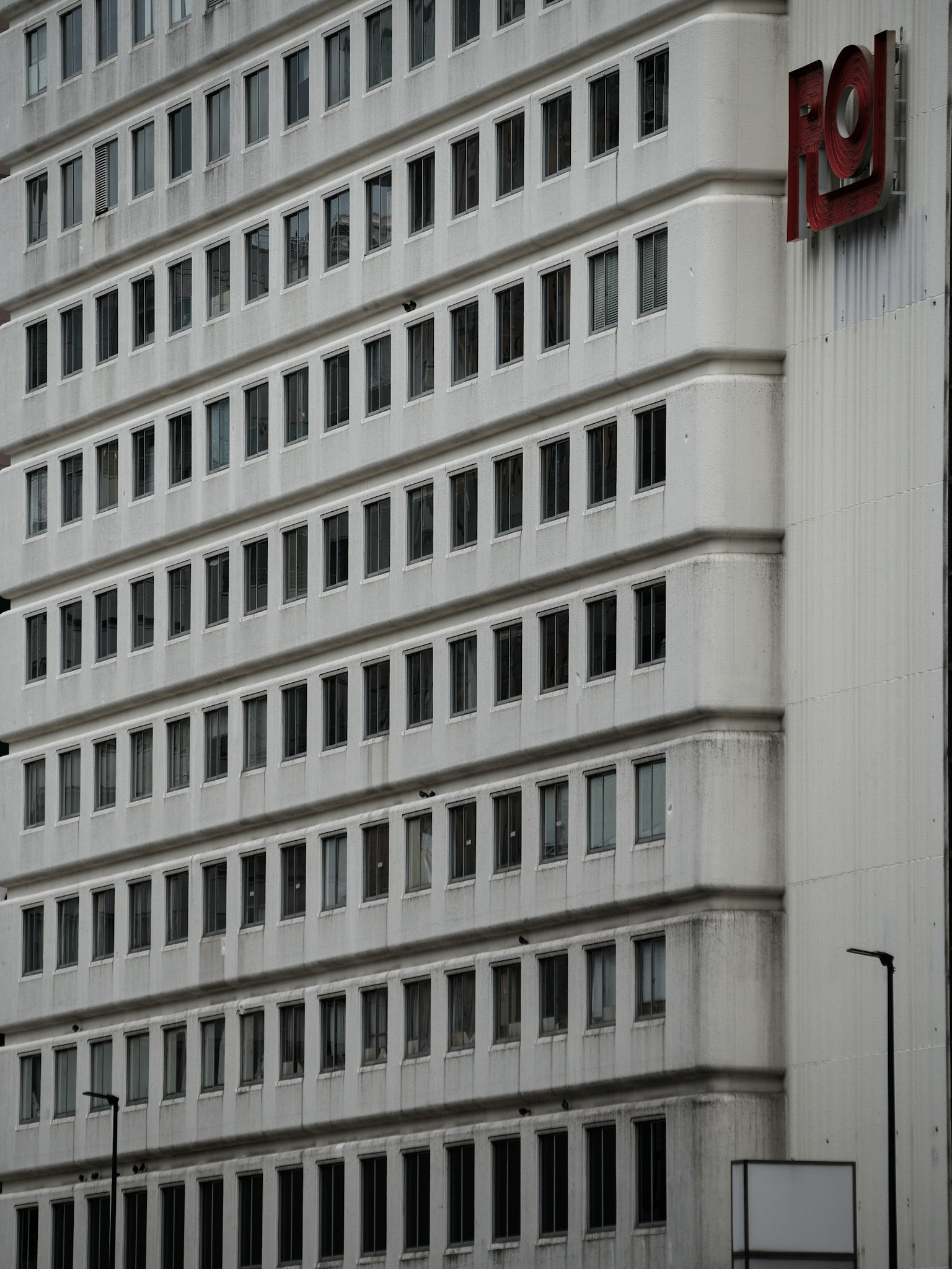 白色建筑外观，整齐的窗户和红色标志