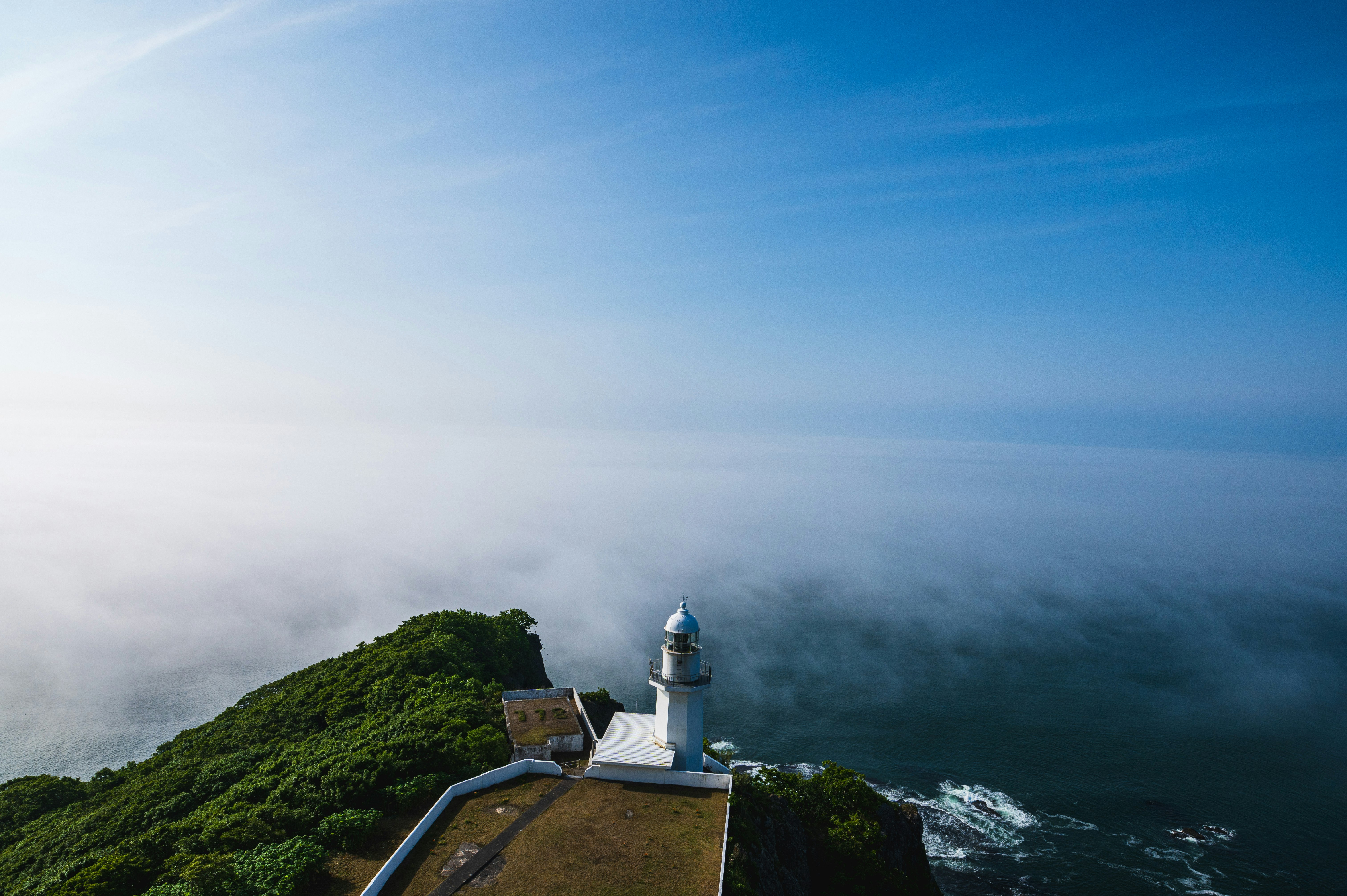 Lighthouse and viewing deck emerging from sea fog
