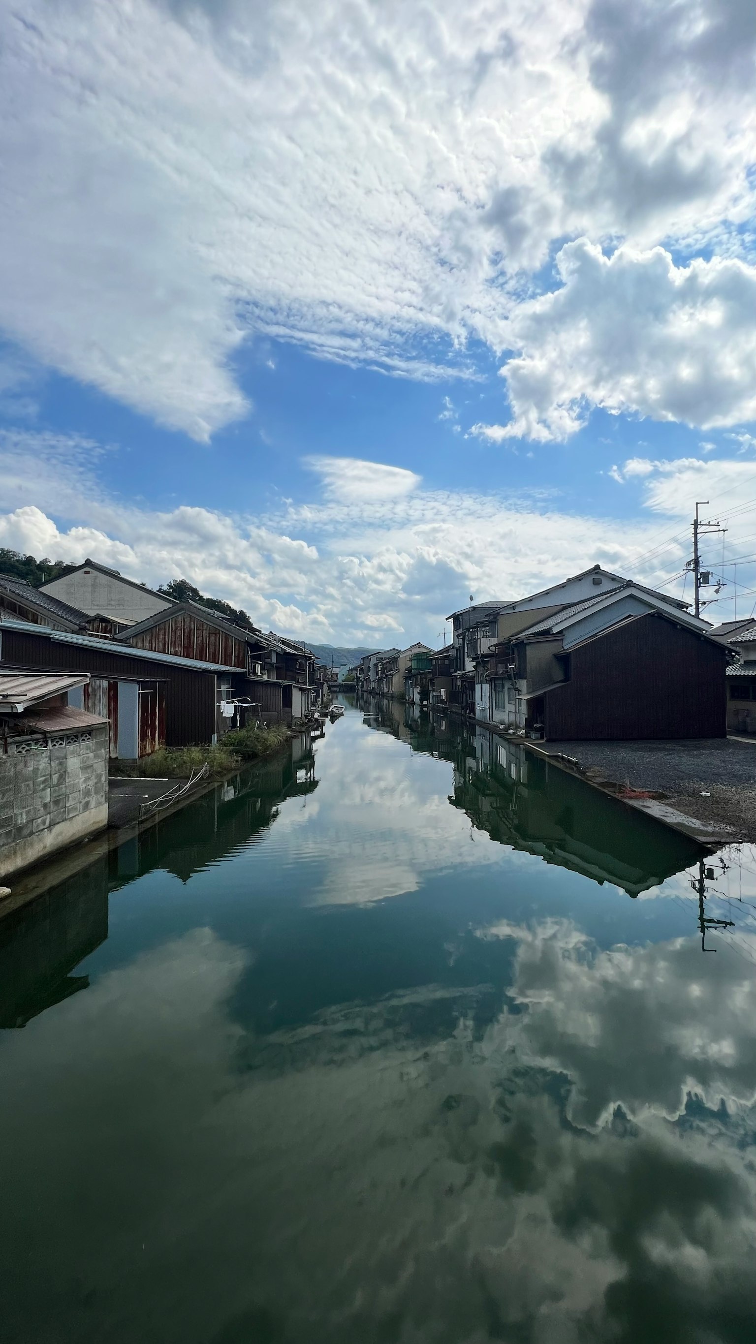 Canale tranquillo che riflette nuvole e case