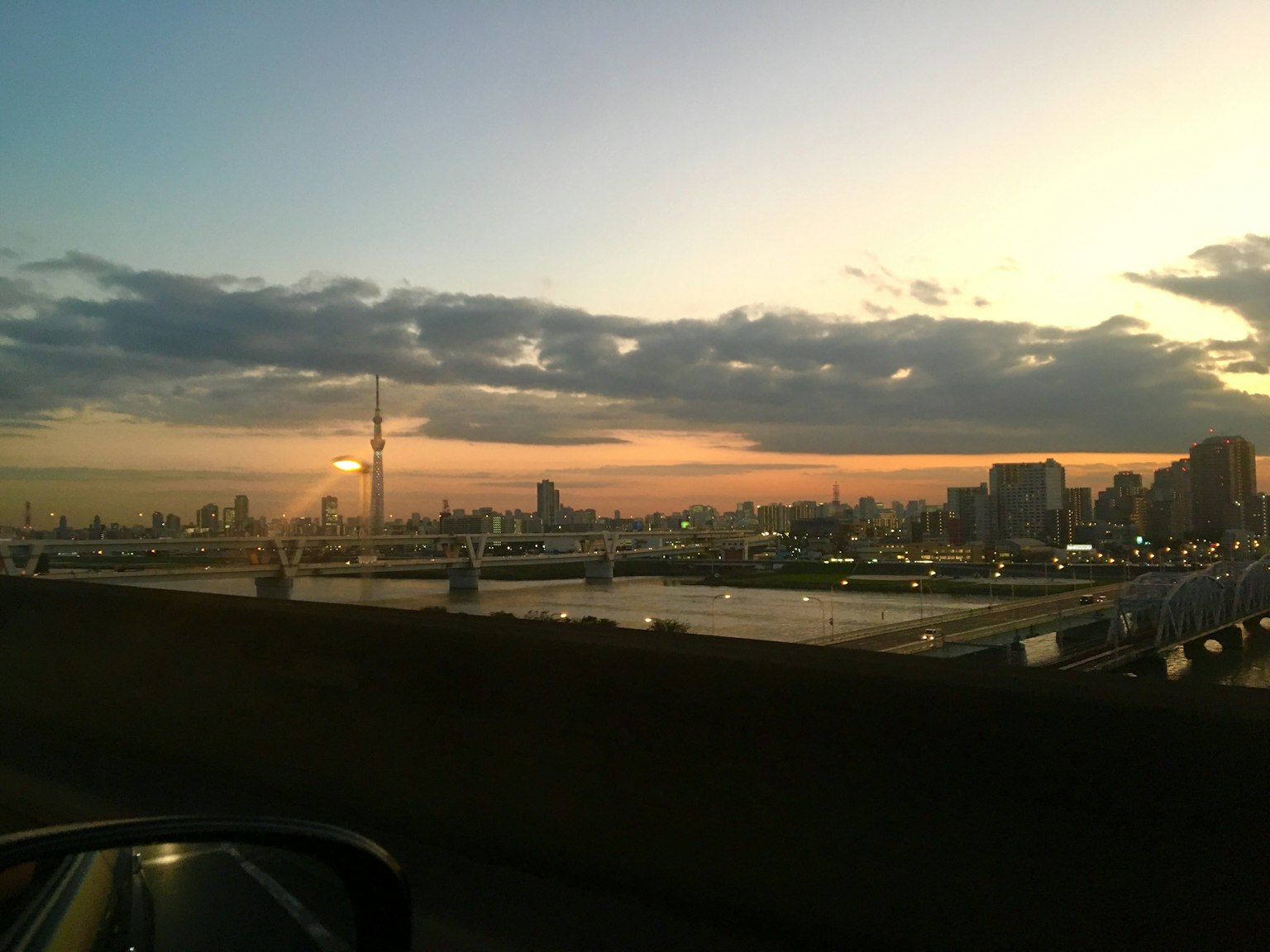 Ciel de Tokyo au coucher du soleil avec des gratte-ciels et des reflets sur l'eau
