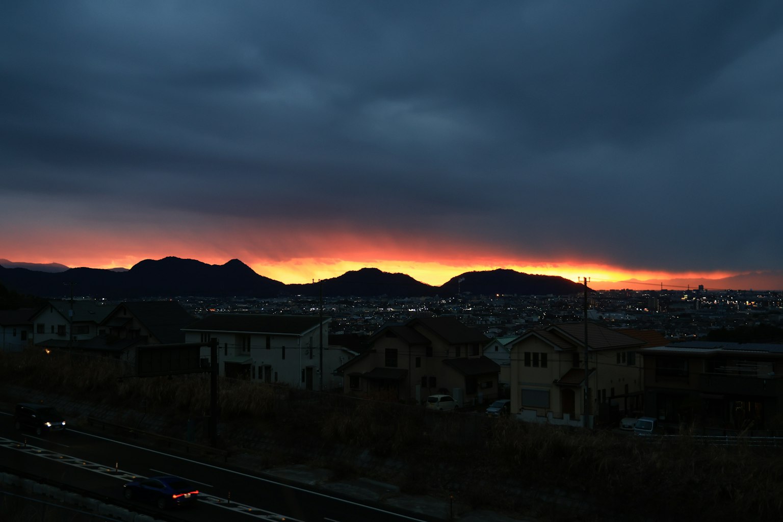 夕焼けに照らされた山々と街の景色