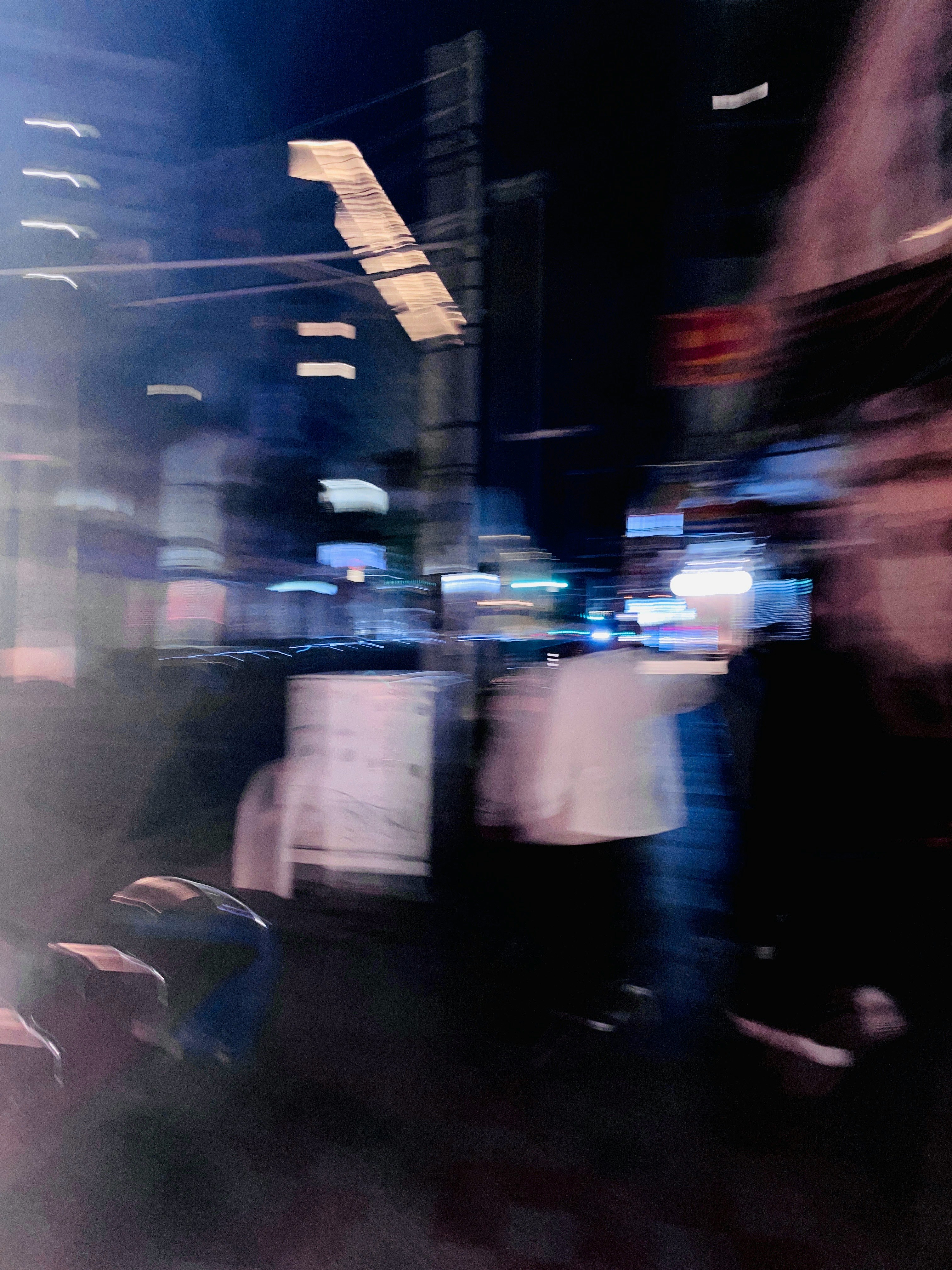 夜の街で流れる光と人の動きのある通り