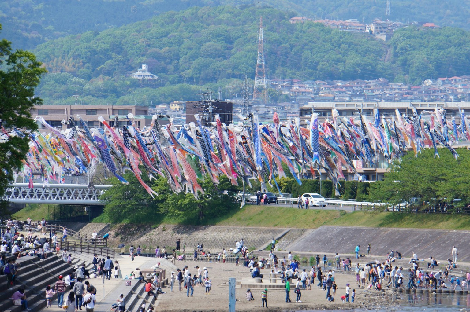 Colorful carp streamers near a river with a crowd of people