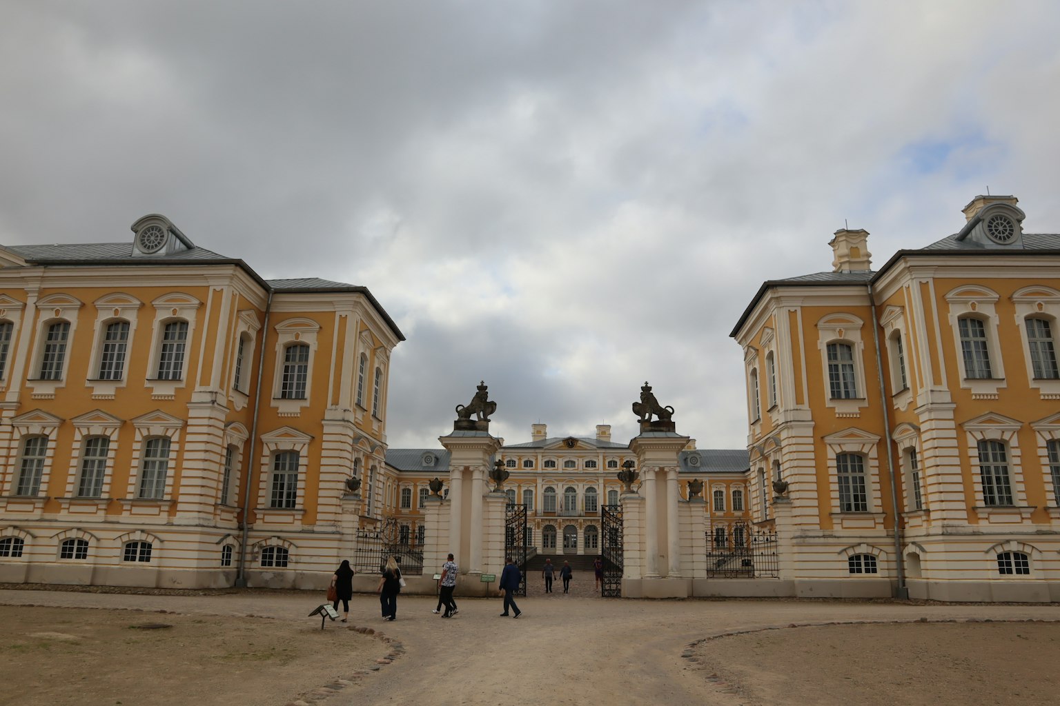 Des gens marchent devant des bâtiments jaunes et blancs dans une place