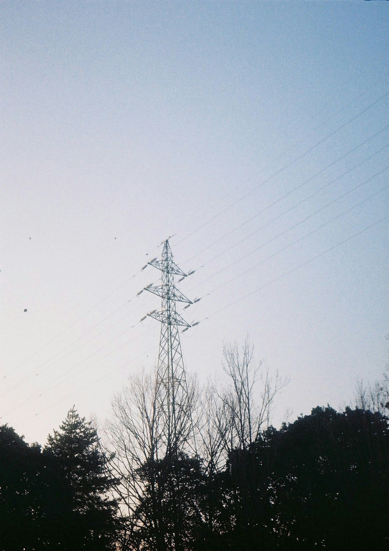 Silueta de una torre eléctrica contra un cielo iluminado