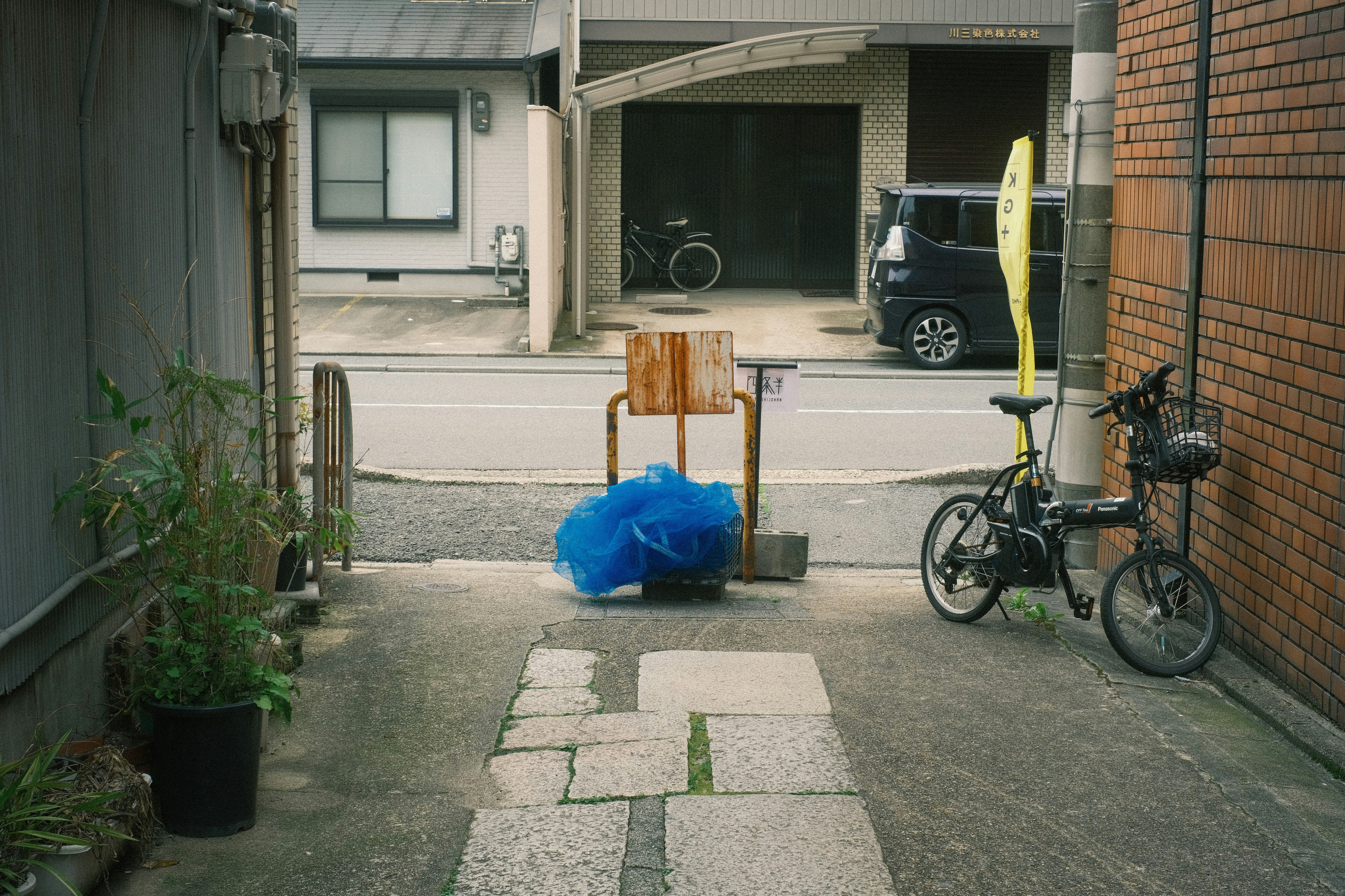 bicycle et sac poubelle posés le long d’un passage étroit