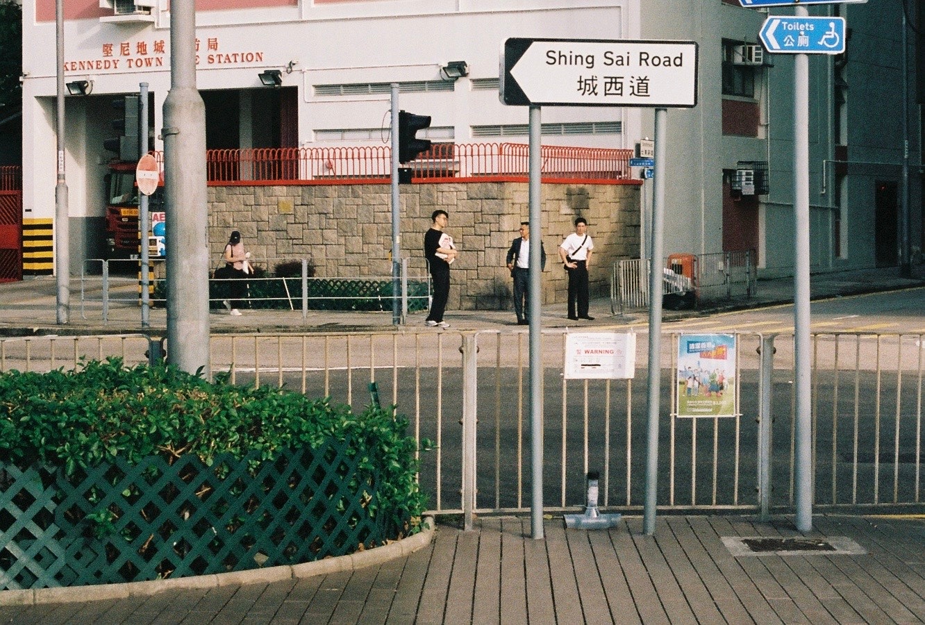 sidewalk with railings and station wayfinding signs