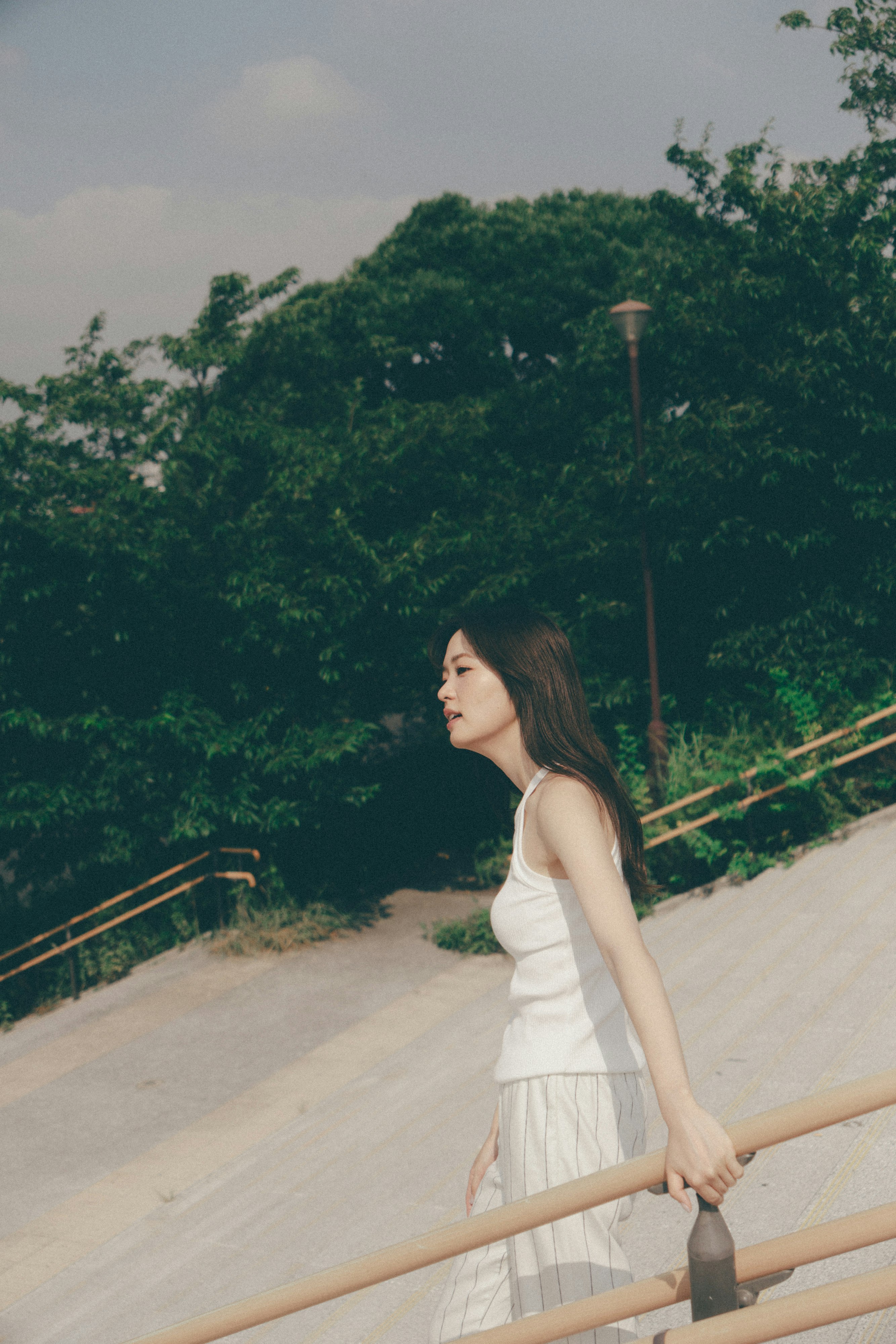 绿意背景下的步道上站立的女性