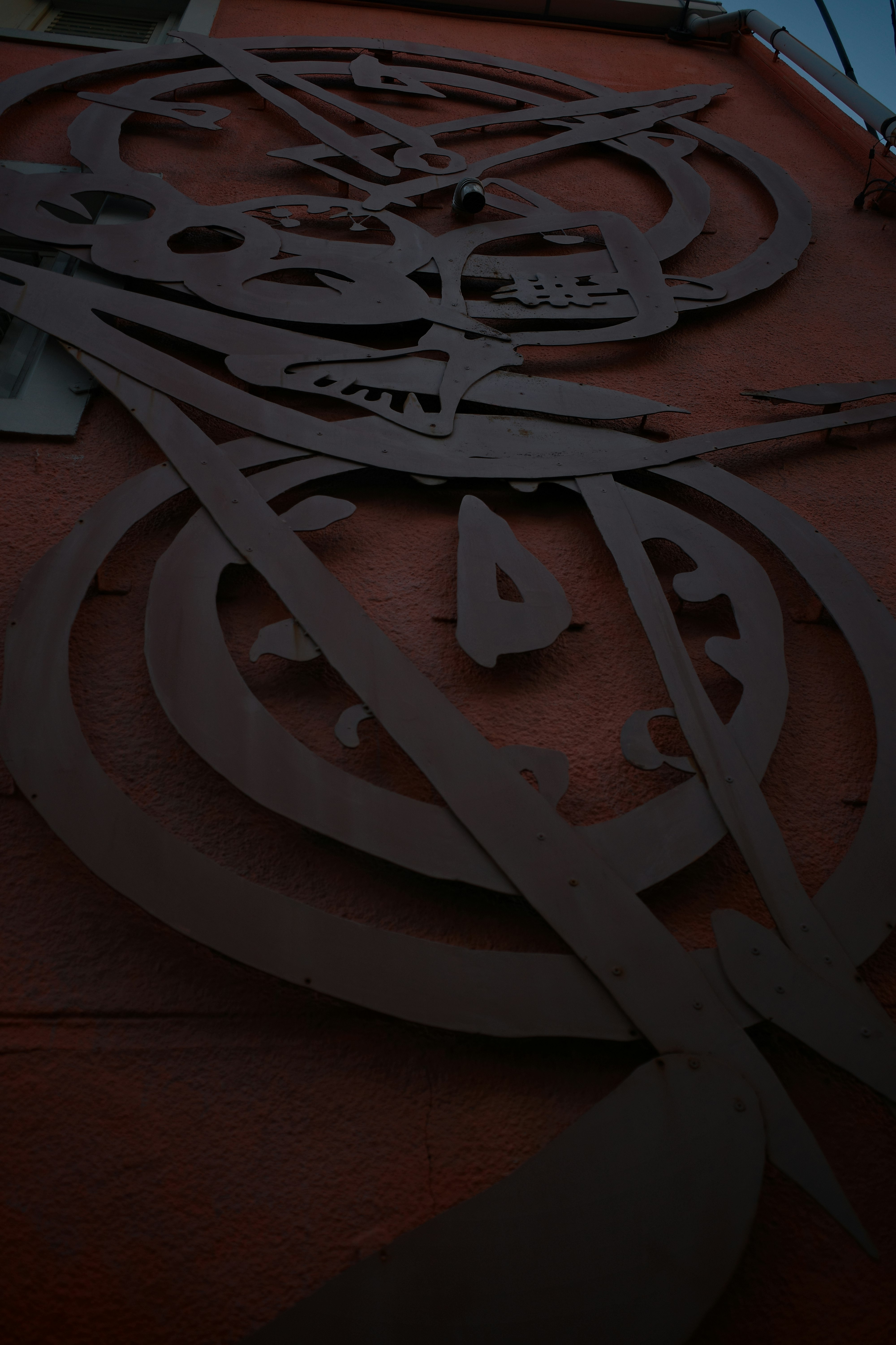 Escultura de metal abstracta sobre un fondo rojo