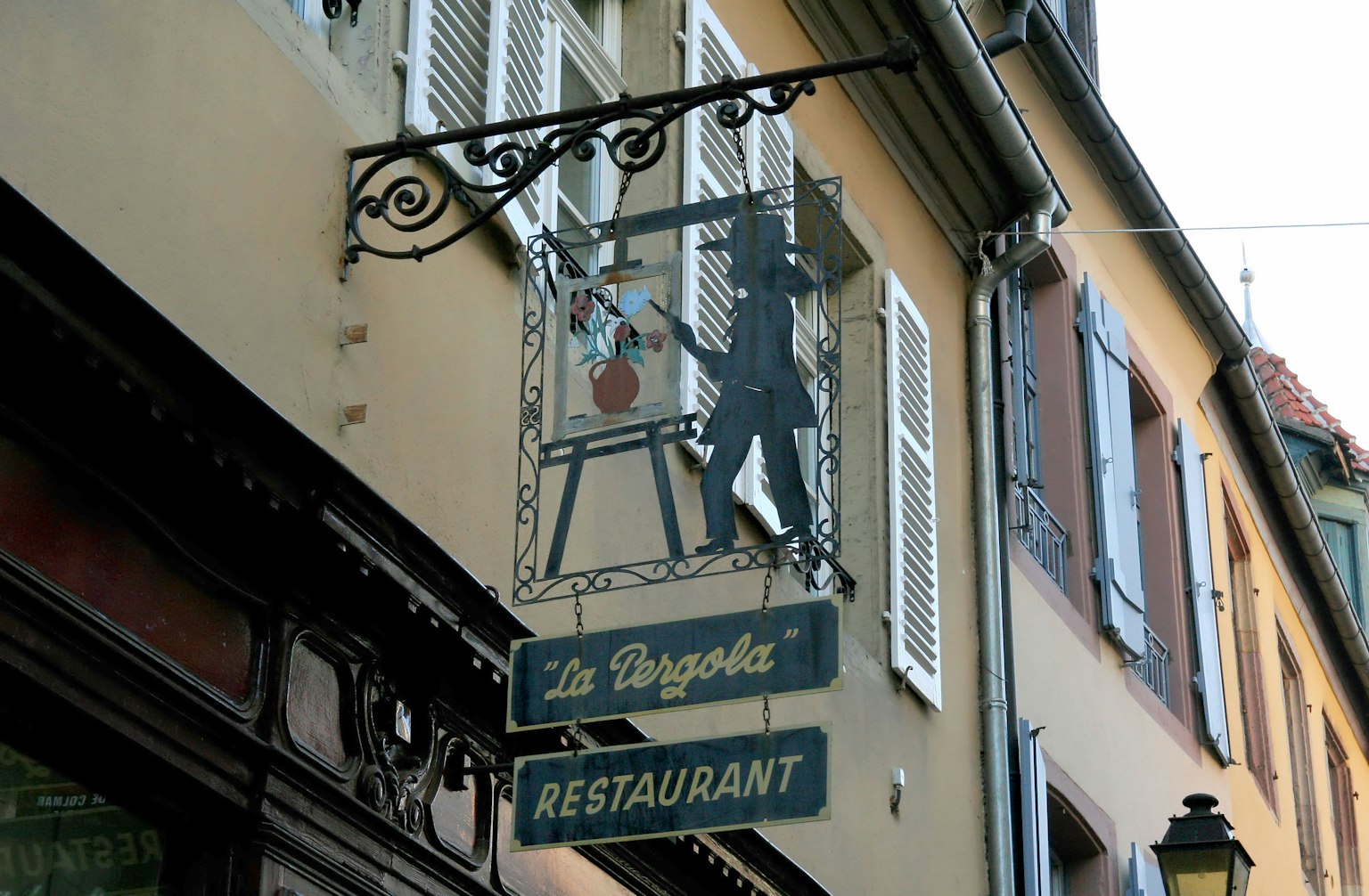 Insegna di ristorante con silhouette di un pittore e una tavolozza colorata