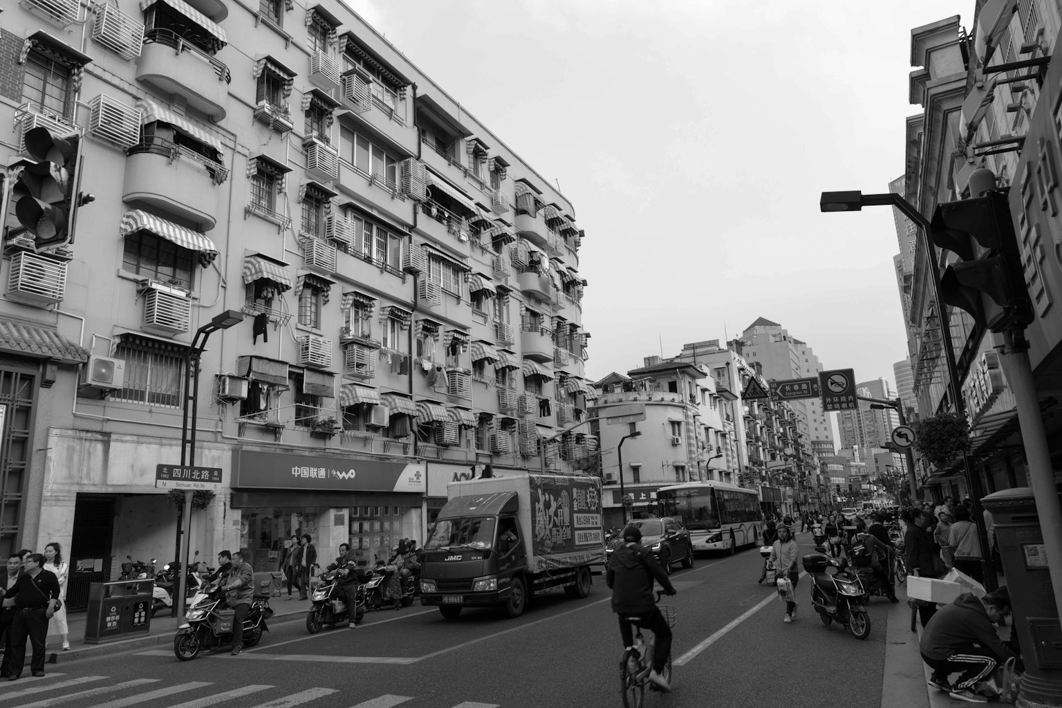 Urban street scene with bicycles and buses along the road featuring old buildings