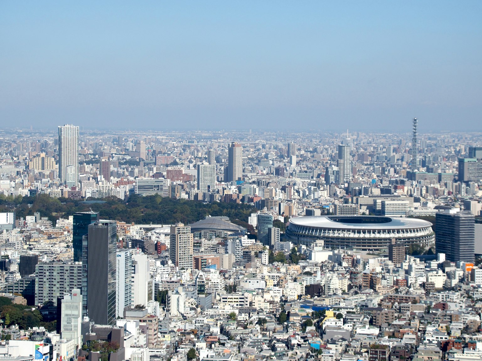 A panoramic view of Tokyo's cityscape featuring a stadium