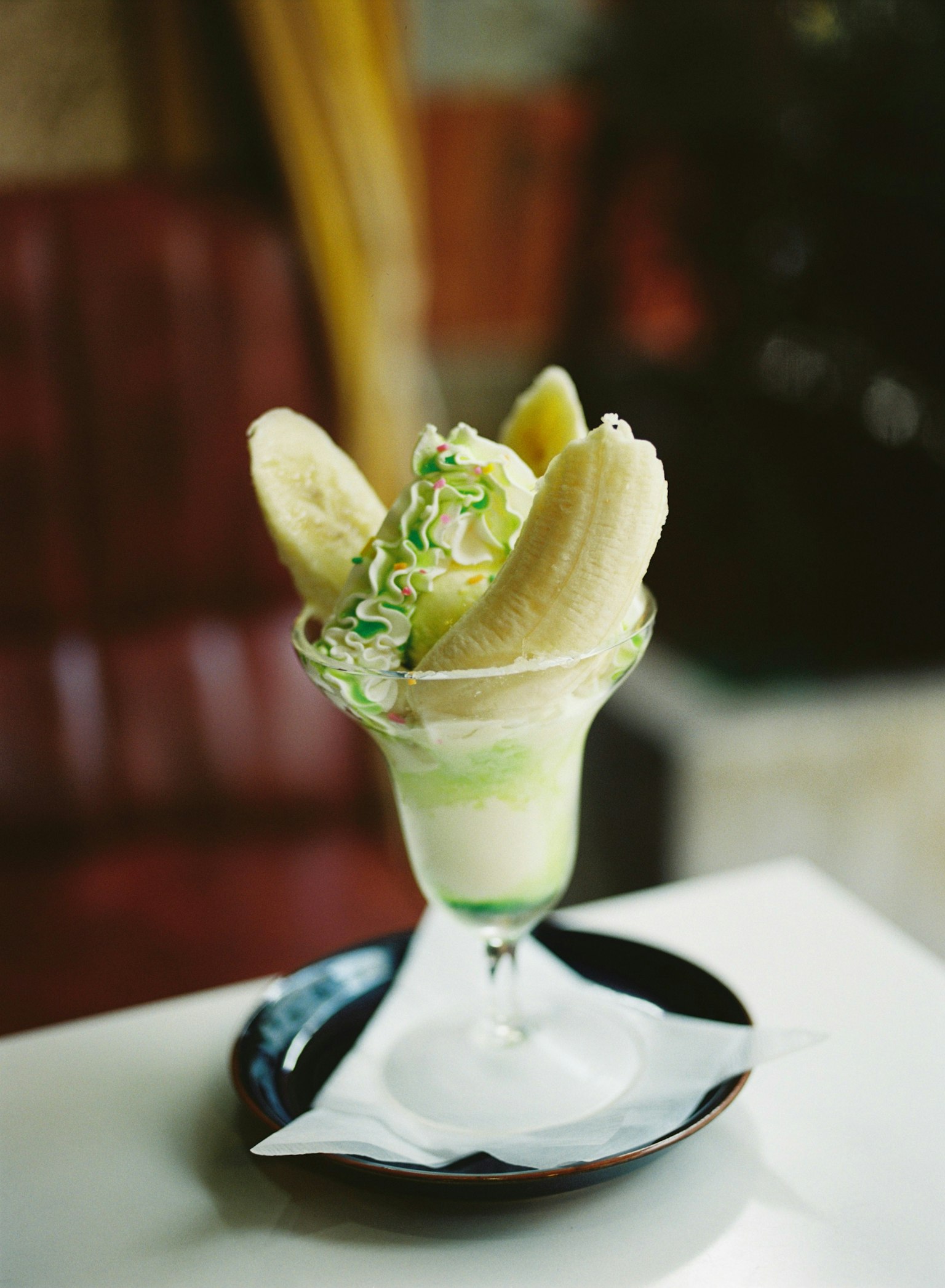 Vaso de postre lleno de plátanos y crema verde