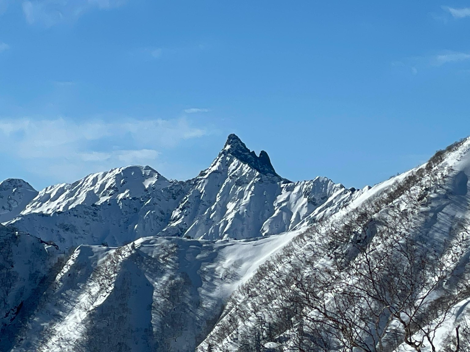 雪覆蓋的山峰在晴朗的藍天下