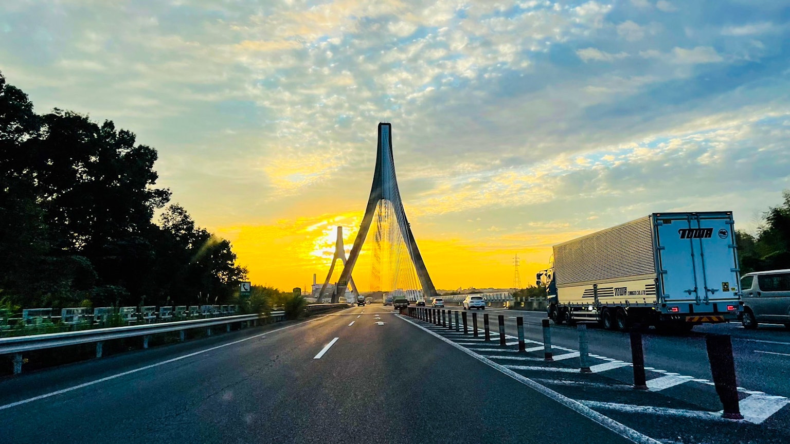 Vue pittoresque d'un pont et d'une route avec un coucher de soleil