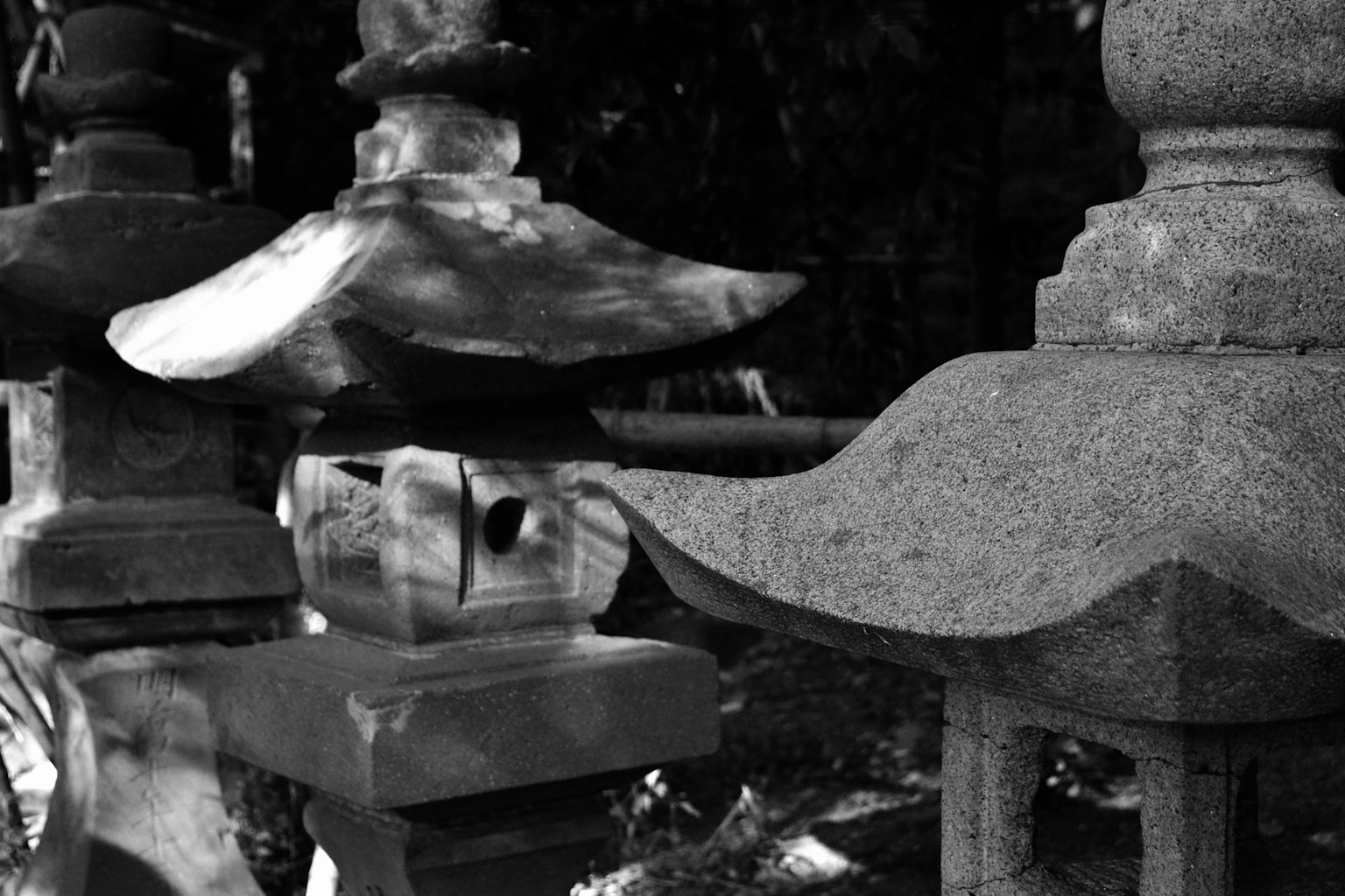 Gros plan de lanternes en pierre en noir et blanc montrant différentes formes et textures