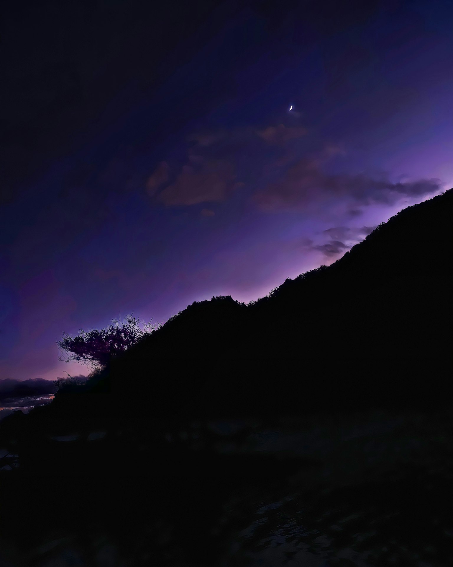 Scène de crépuscule avec un ciel violet et des montagnes en silhouette