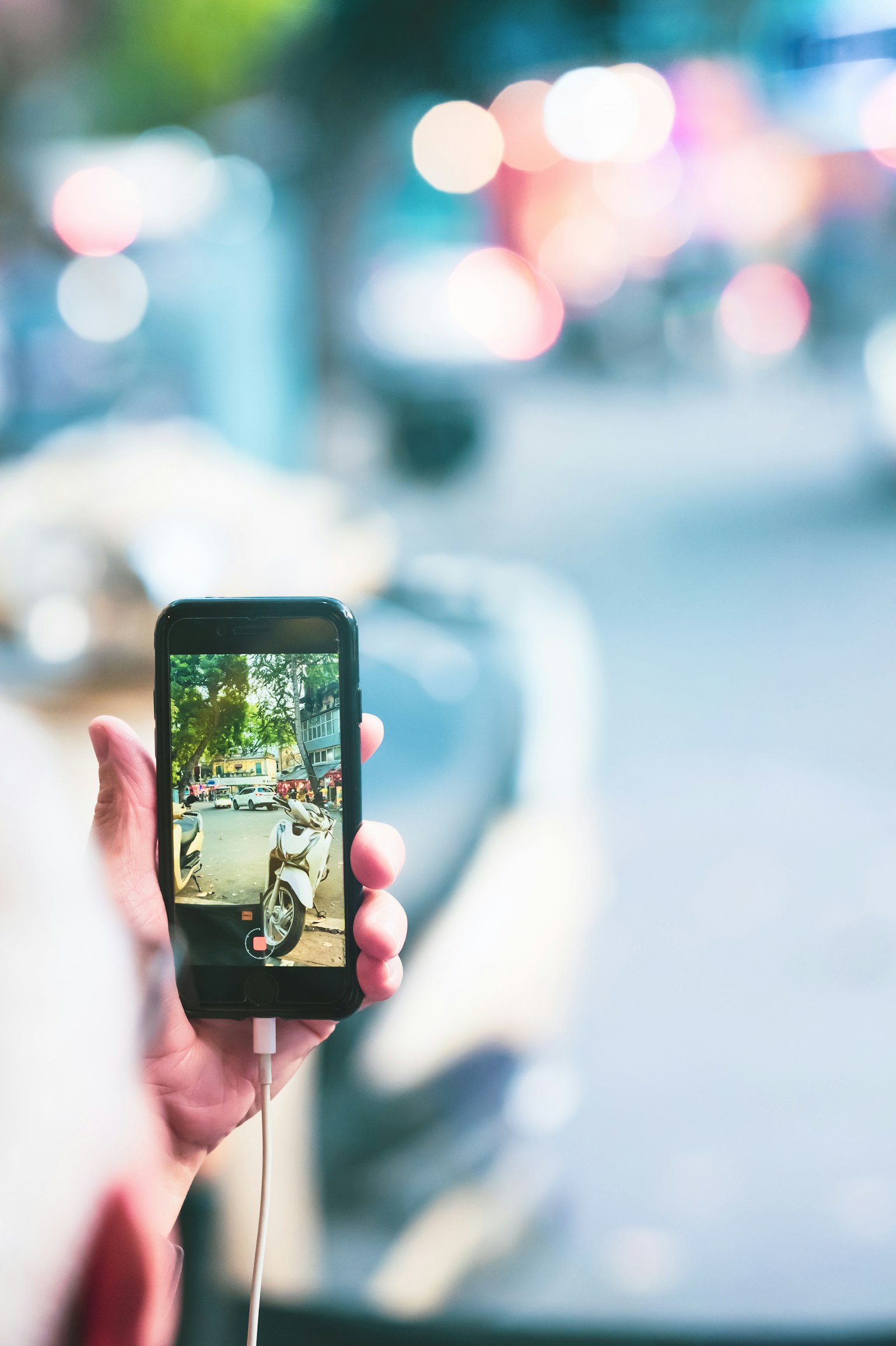Un smartphone tenu dans une main affichant une image avec un arrière-plan flou