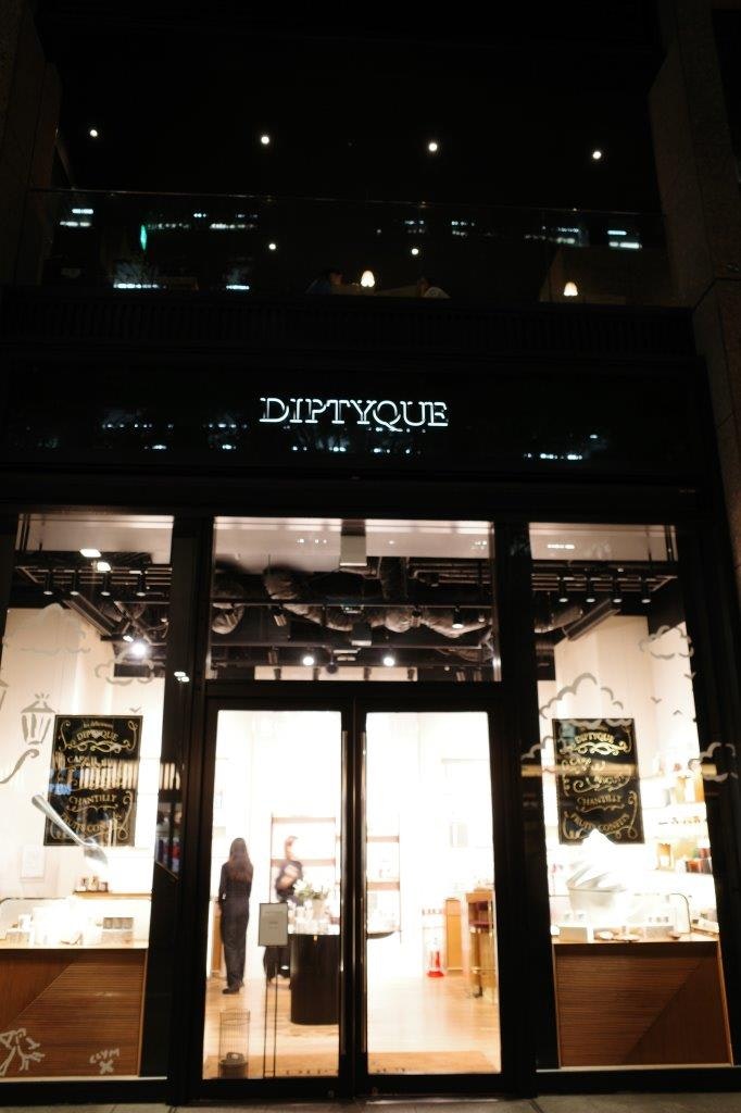 夜のショーウィンドウに並ぶディスプレイと看板「DIPTYQUE」