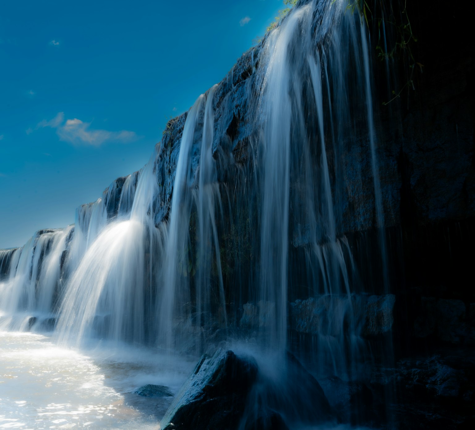 Una bella cascata che scorre sotto un cielo blu