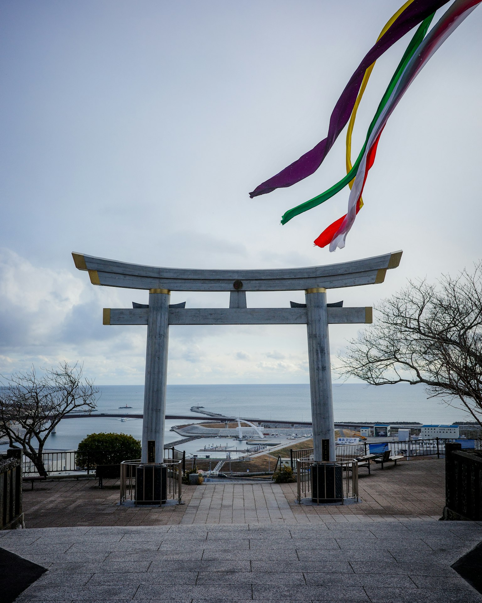 鳥居和五彩繽紛的彩帶背景下的藍色海洋