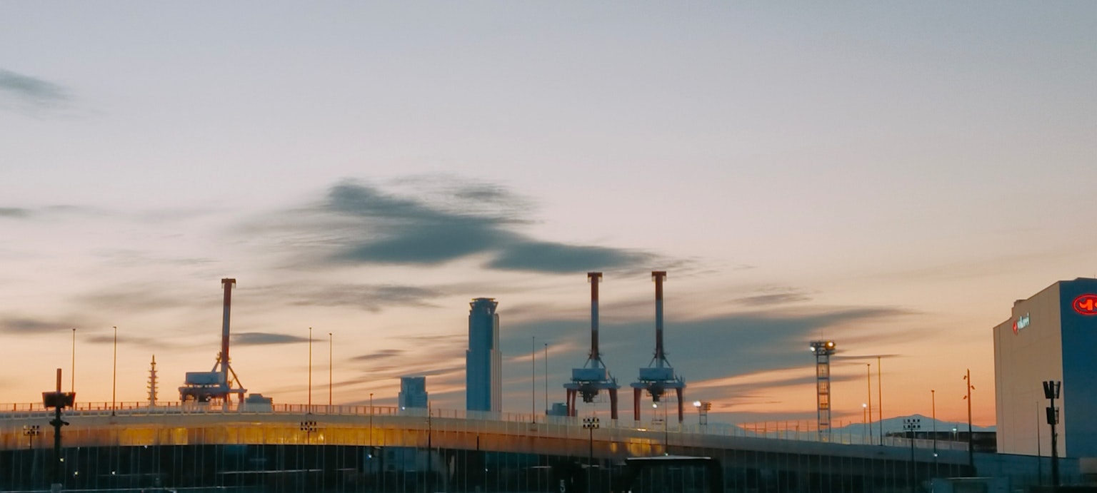Paysage industriel au coucher du soleil avec des cheminées et des gratte-ciels
