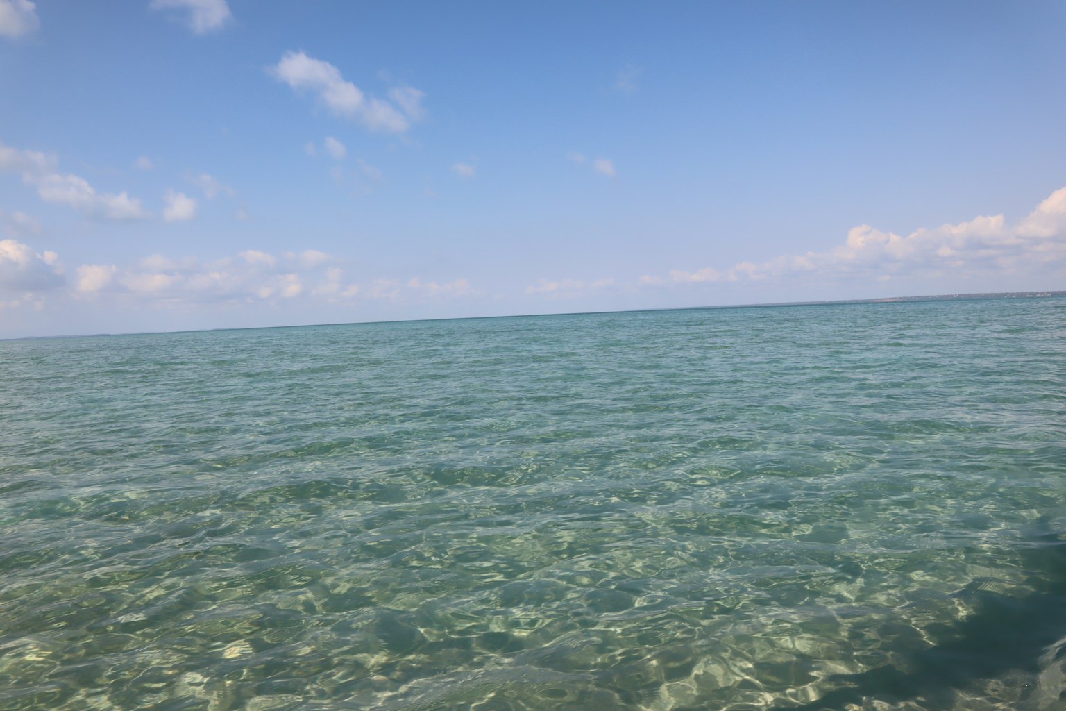 Superficie d'acqua chiara con cielo blu sopra l'oceano