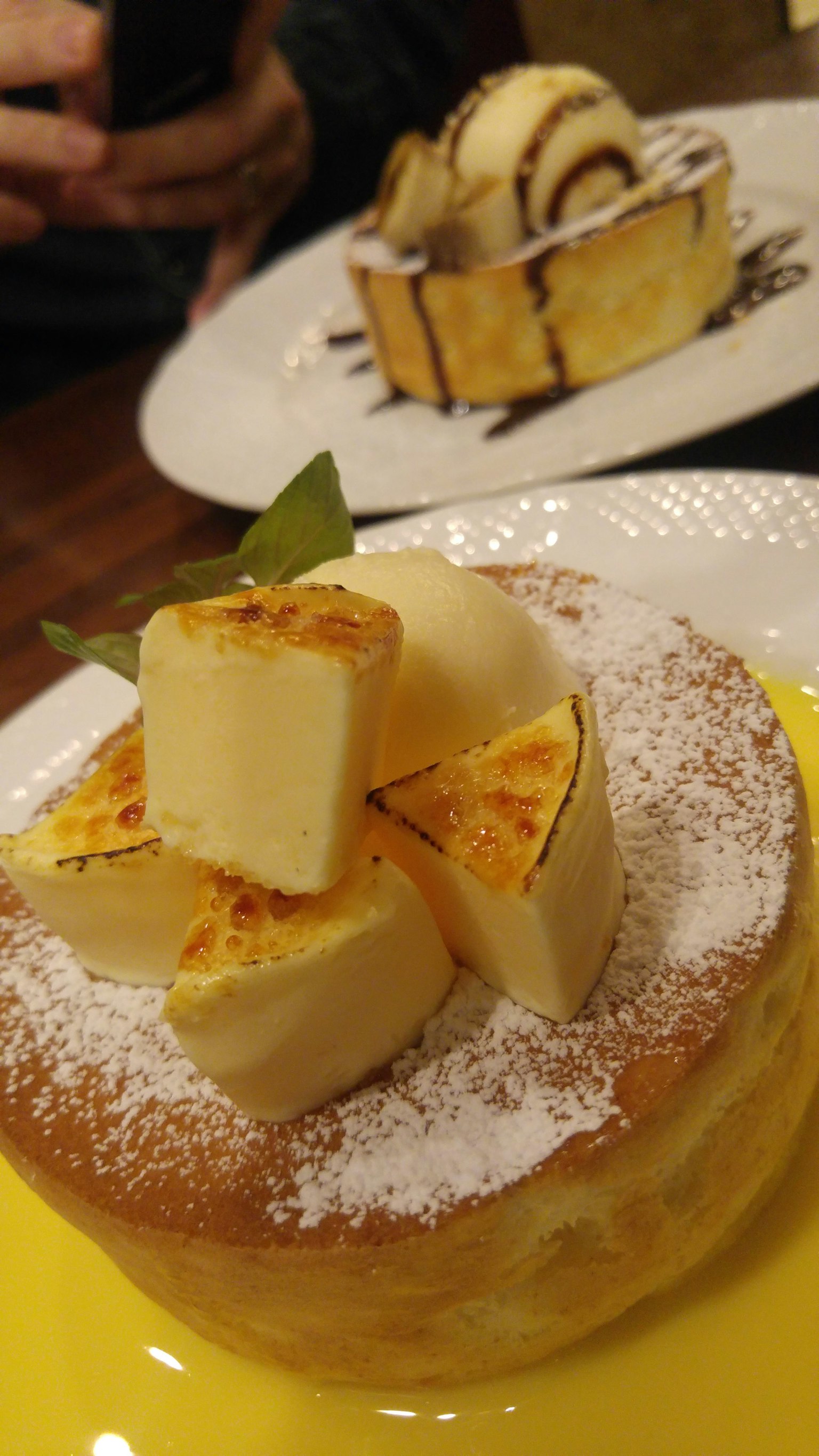 Cheesecake soffice guarnito con pezzi di formaggio quadrati e zucchero a velo