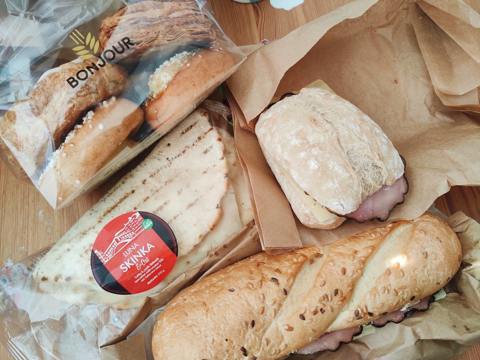 Kumpulan roti dan sandwich segar di atas permukaan kayu