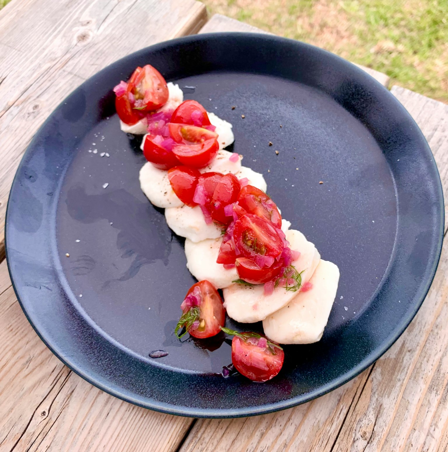 Bananes tranchées garnies de tomates fraîches sur une assiette noire