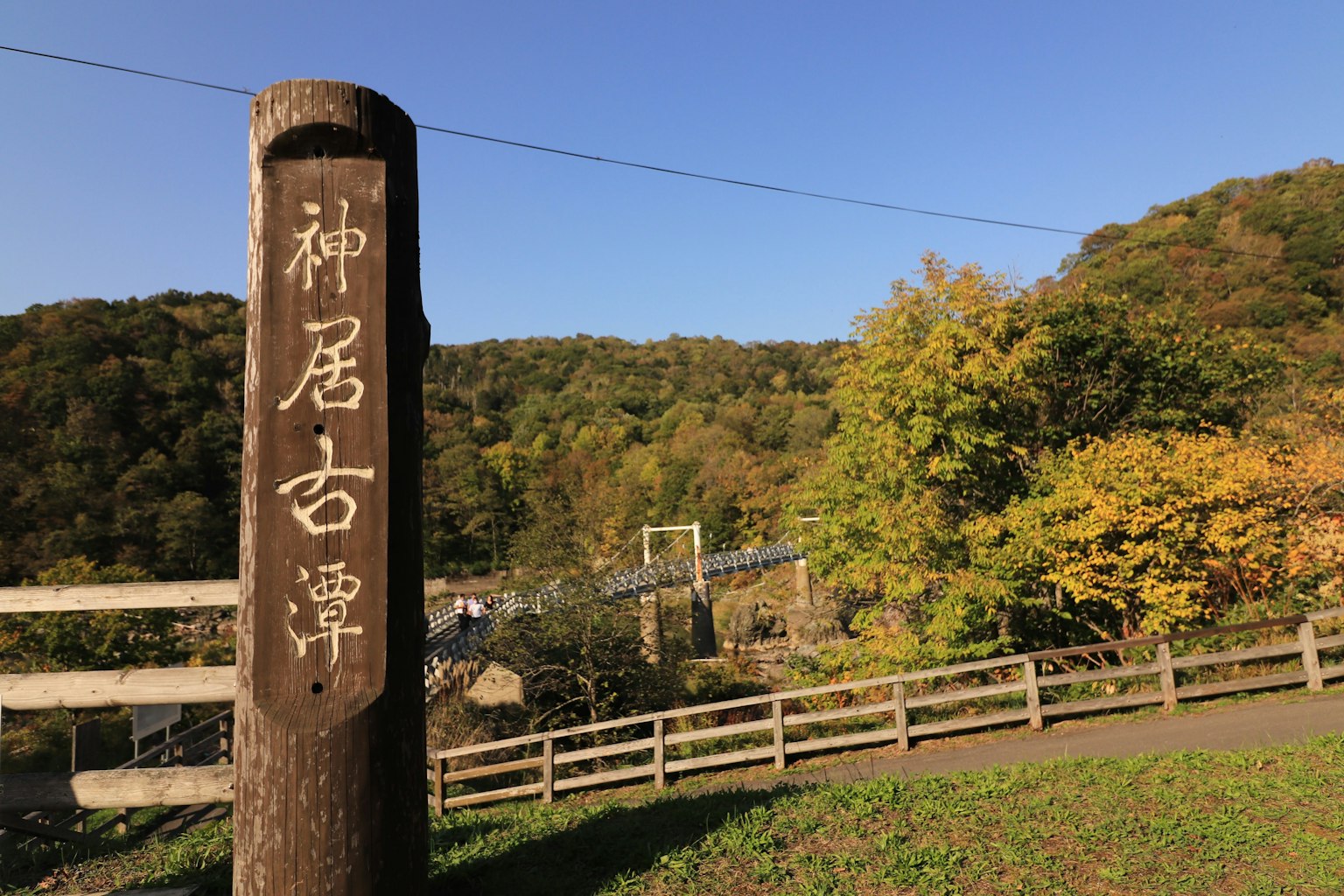 Landschaftsansicht von Kamui Kotan mit einem alten Steinsäule und Herbstlaub