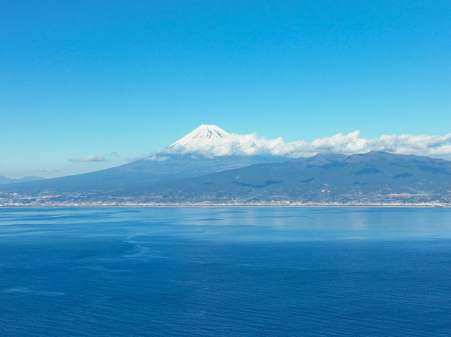 Mont enneigé entouré par un ciel et une mer bleus
