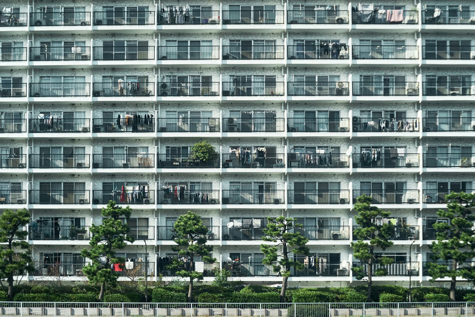 ภาพภายนอกของอาคารอพาร์ตเมนต์สูง มีระเบียงและสวน