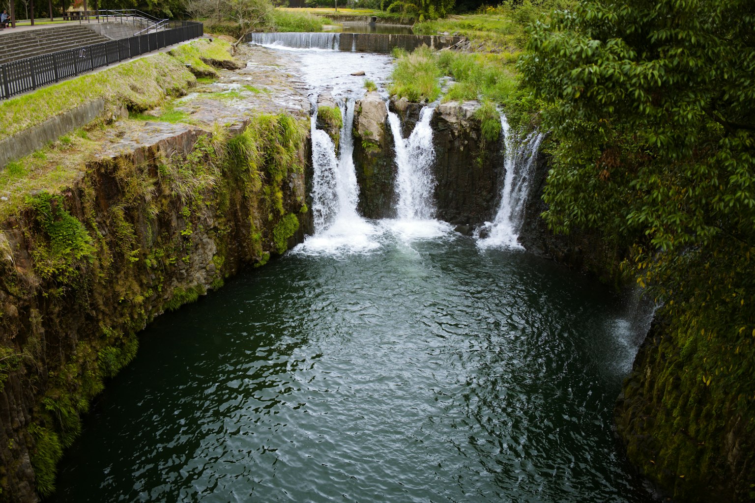 Air terjun yang indah dengan batu hijau subur dan air mengalir