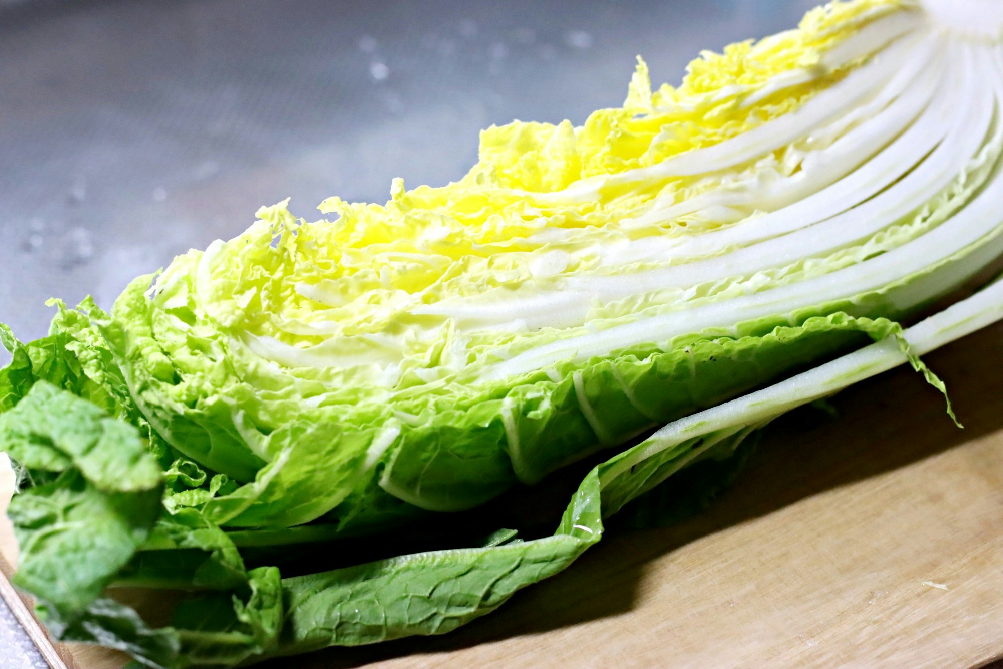 まな板の上に並ぶレタスと黄色い野菜