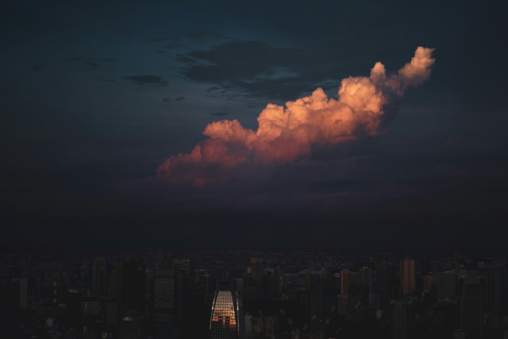 ciel nocturne au-dessus d’une skyline urbaine, nuages de coucher de soleil et lumières de la ville