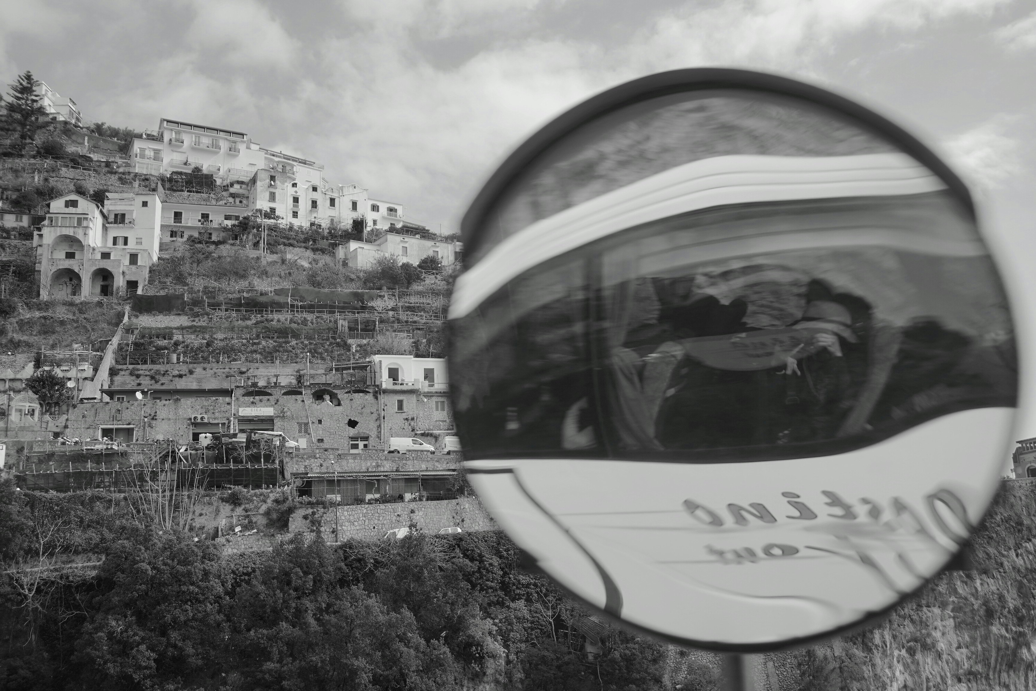 side mirror reflection over hillside houses