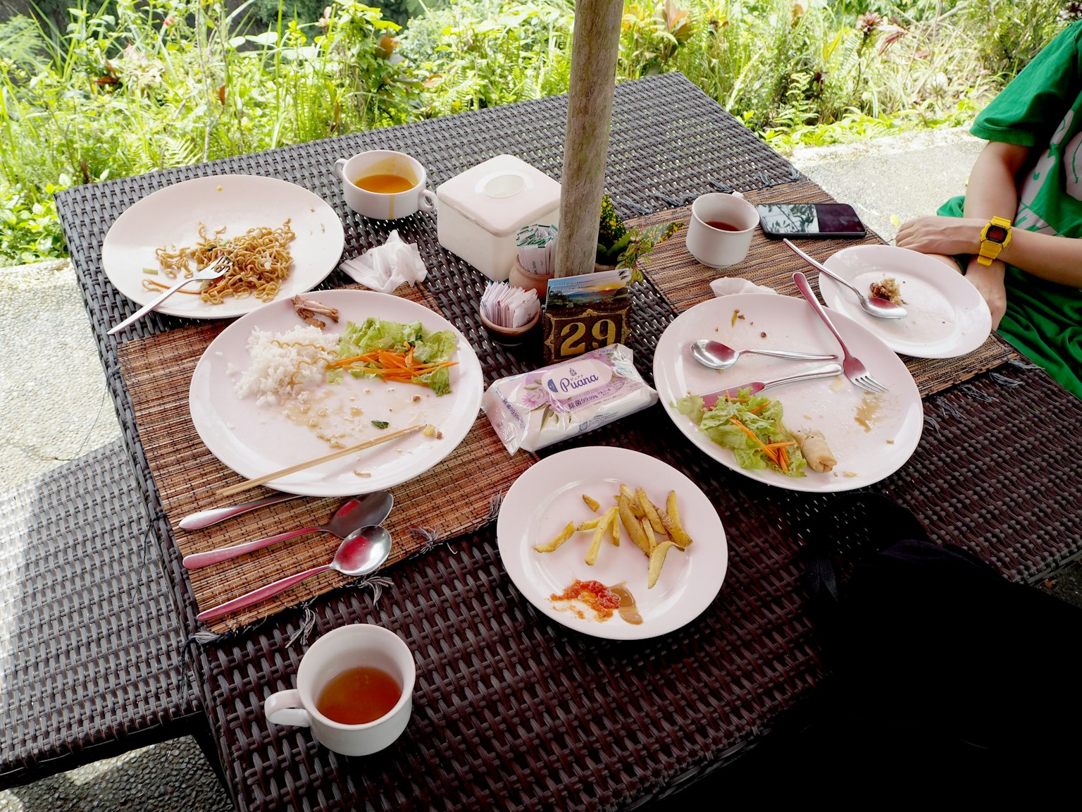 Table avec des restes de nourriture sur des assiettes blanches et du thé