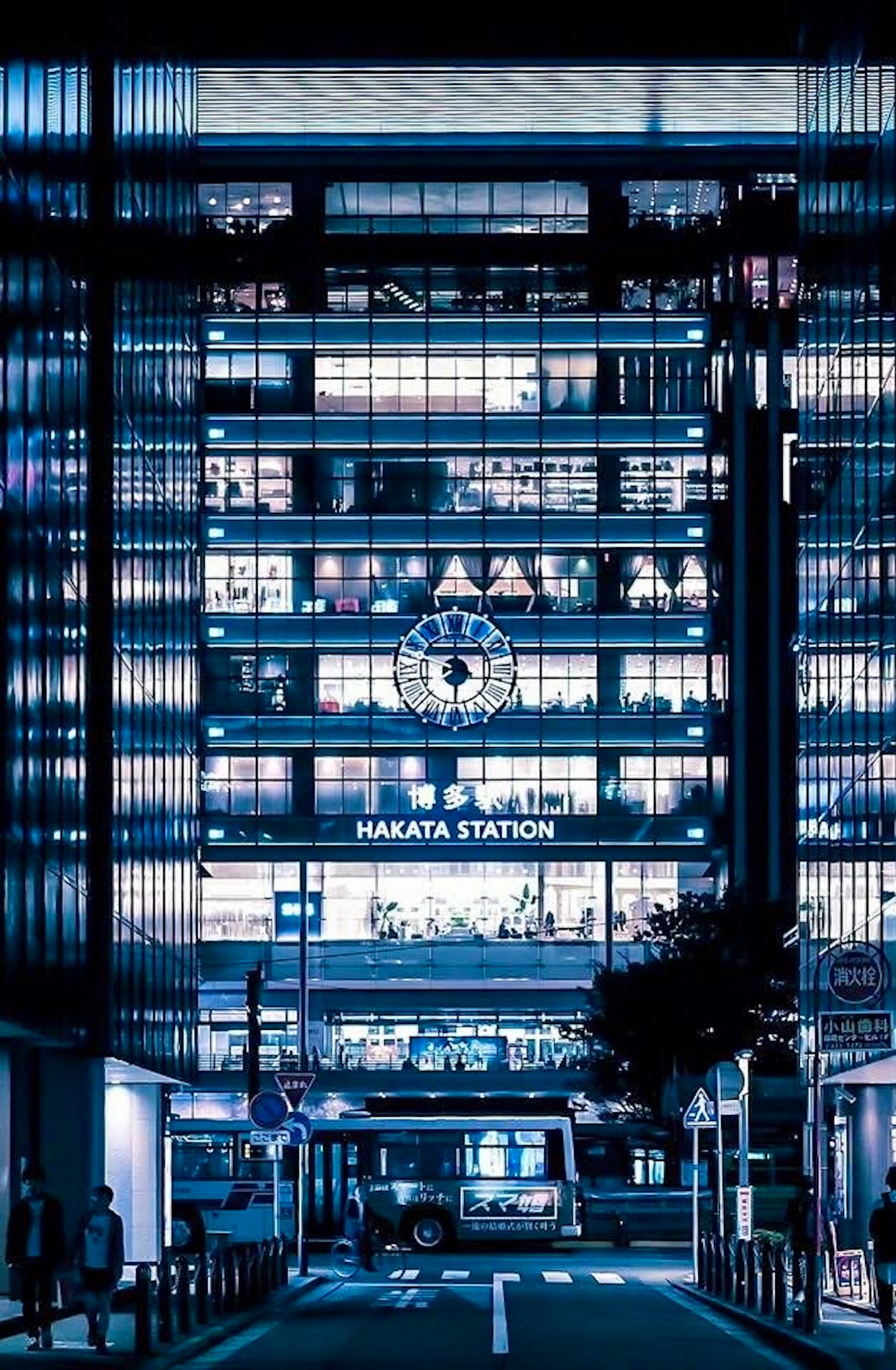 新宿駅の夜景が映るビルの外観と明るい看板